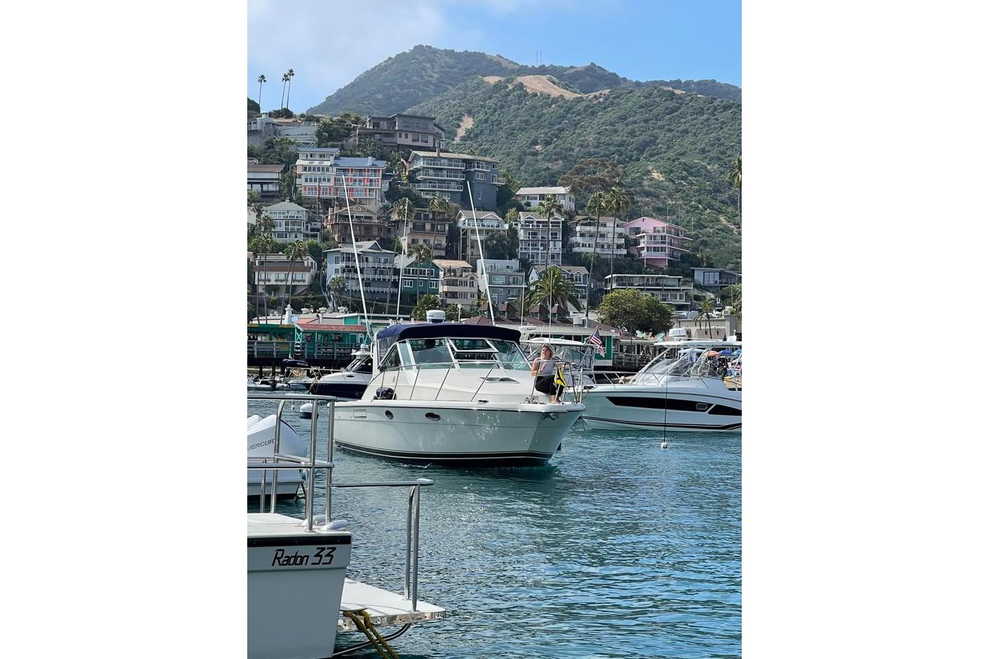 1995 Tiara Yachts 2900 Open in scenic harbor with hillside homes in background.