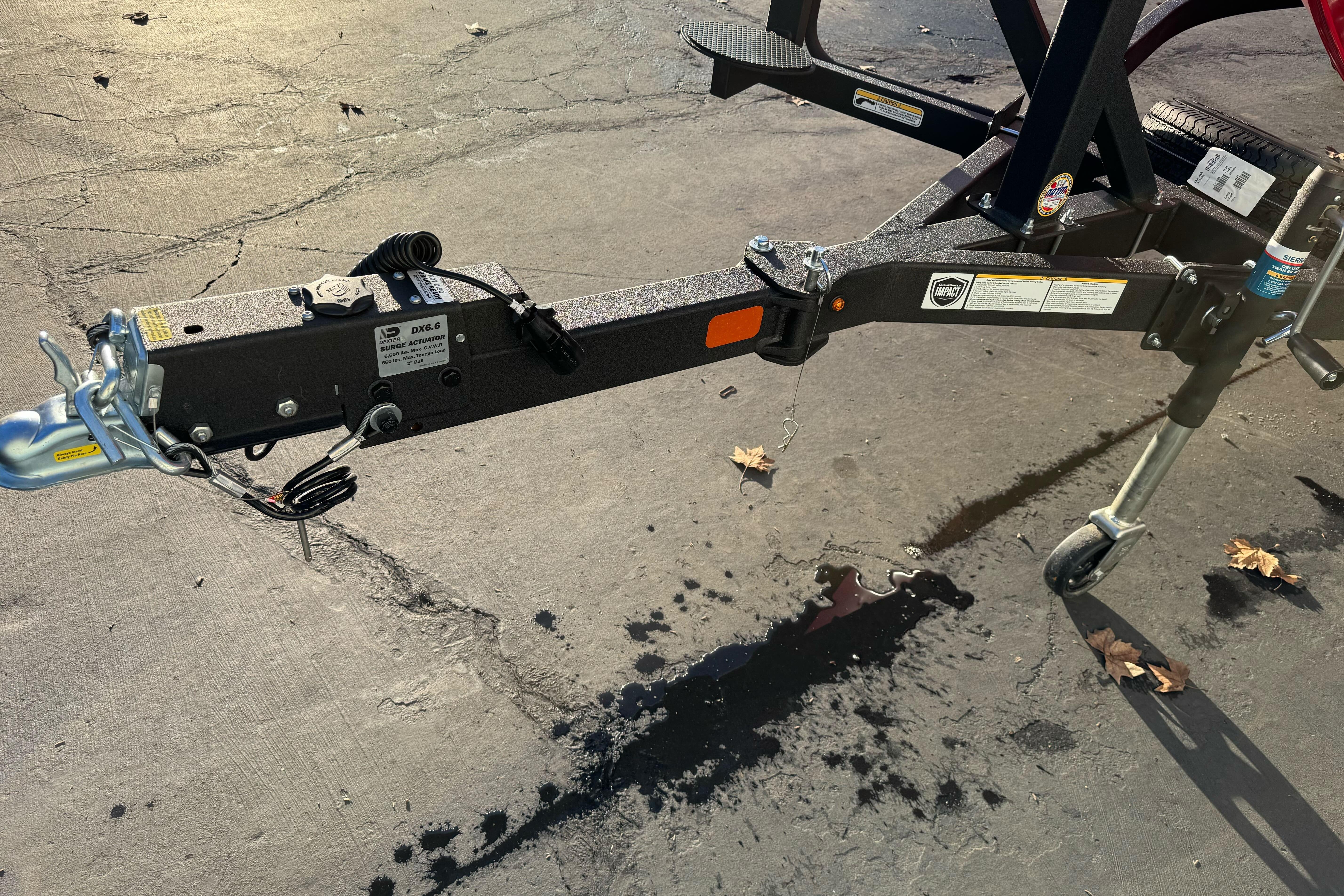 Trailer hitch of 2026 Tracker Targa V-18 WT on pavement with fallen leaves.