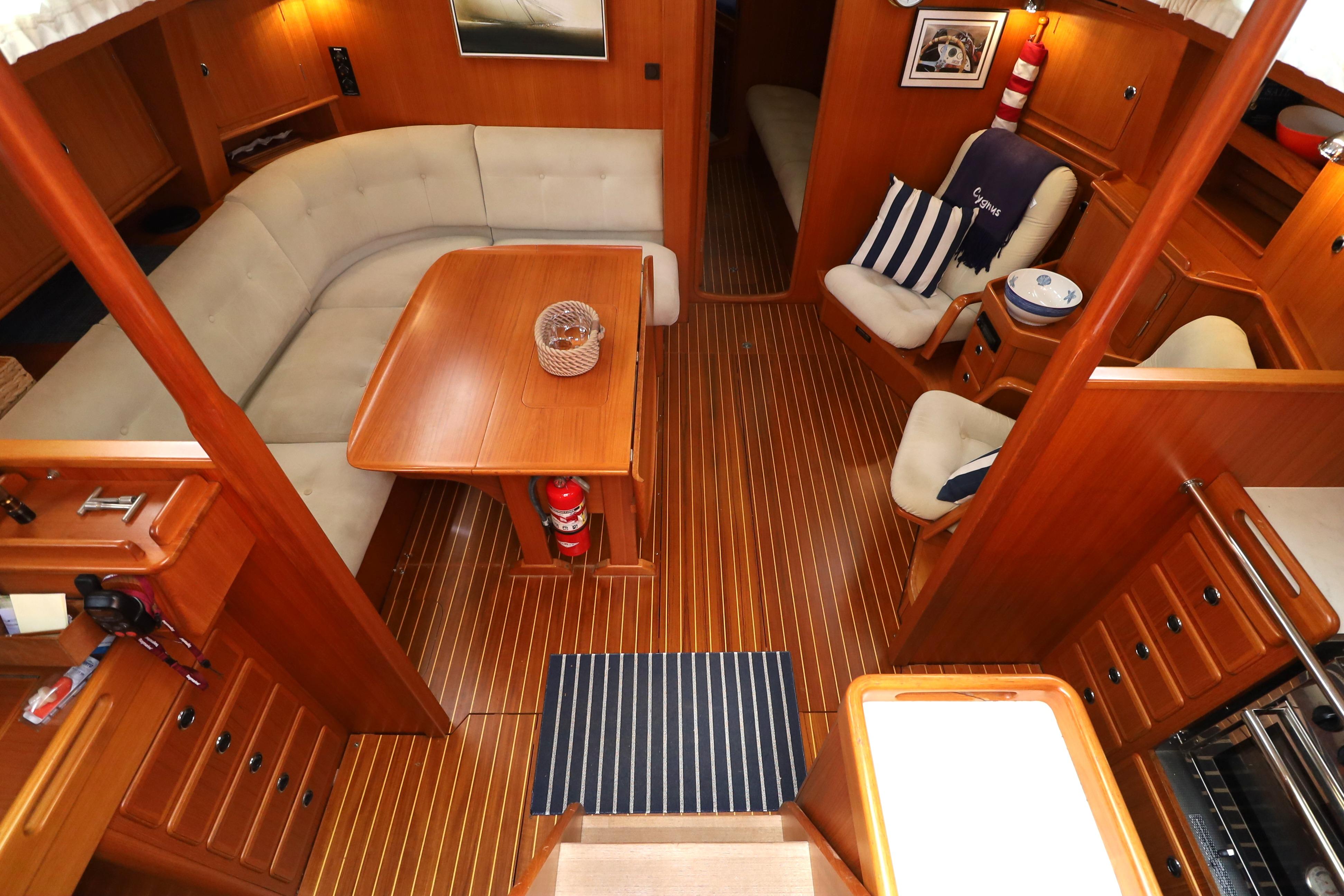Interior of 2000 Hallberg-Rassy 46 yacht with wooden flooring and cozy seating area.