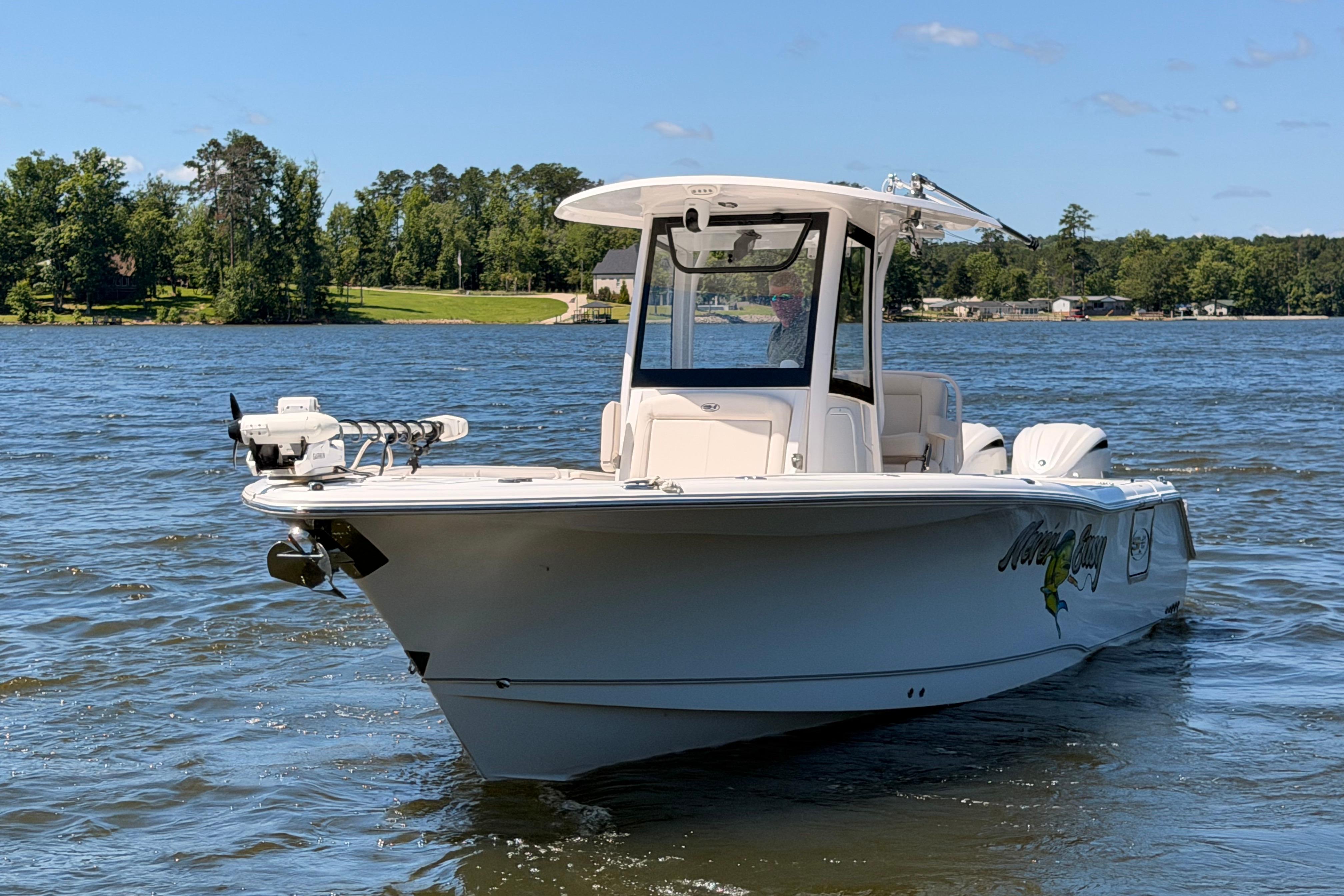 2024 Sea Hunt Gamefish 27 Coffin Box boat on a scenic lake.