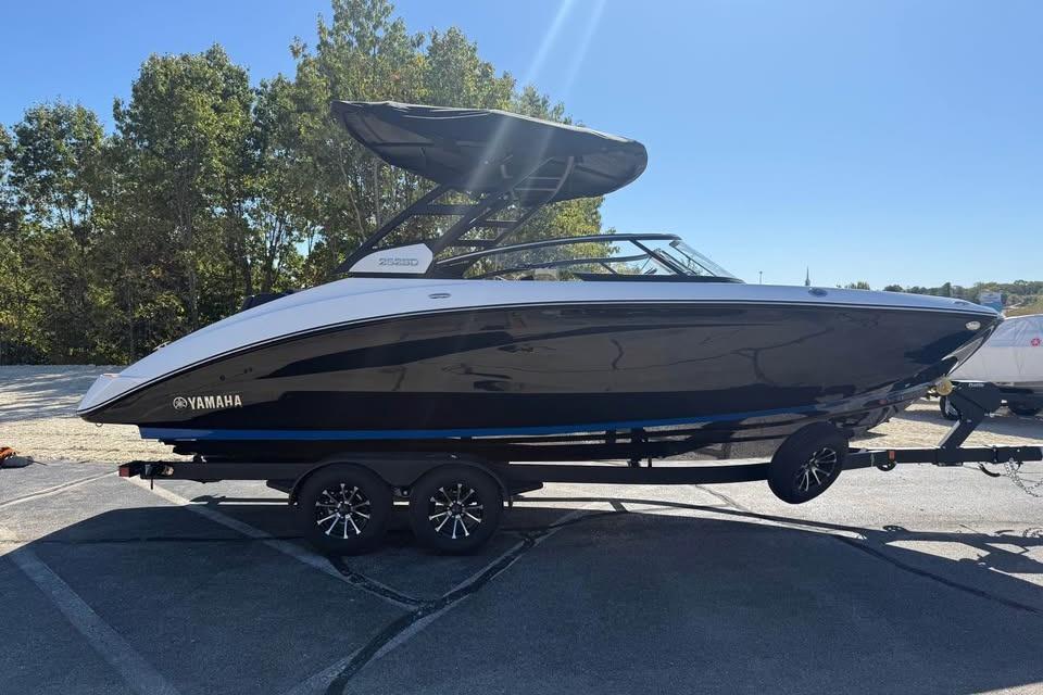 2026 Yamaha Boats 252SD on trailer, sleek black and white design, parked outdoors.