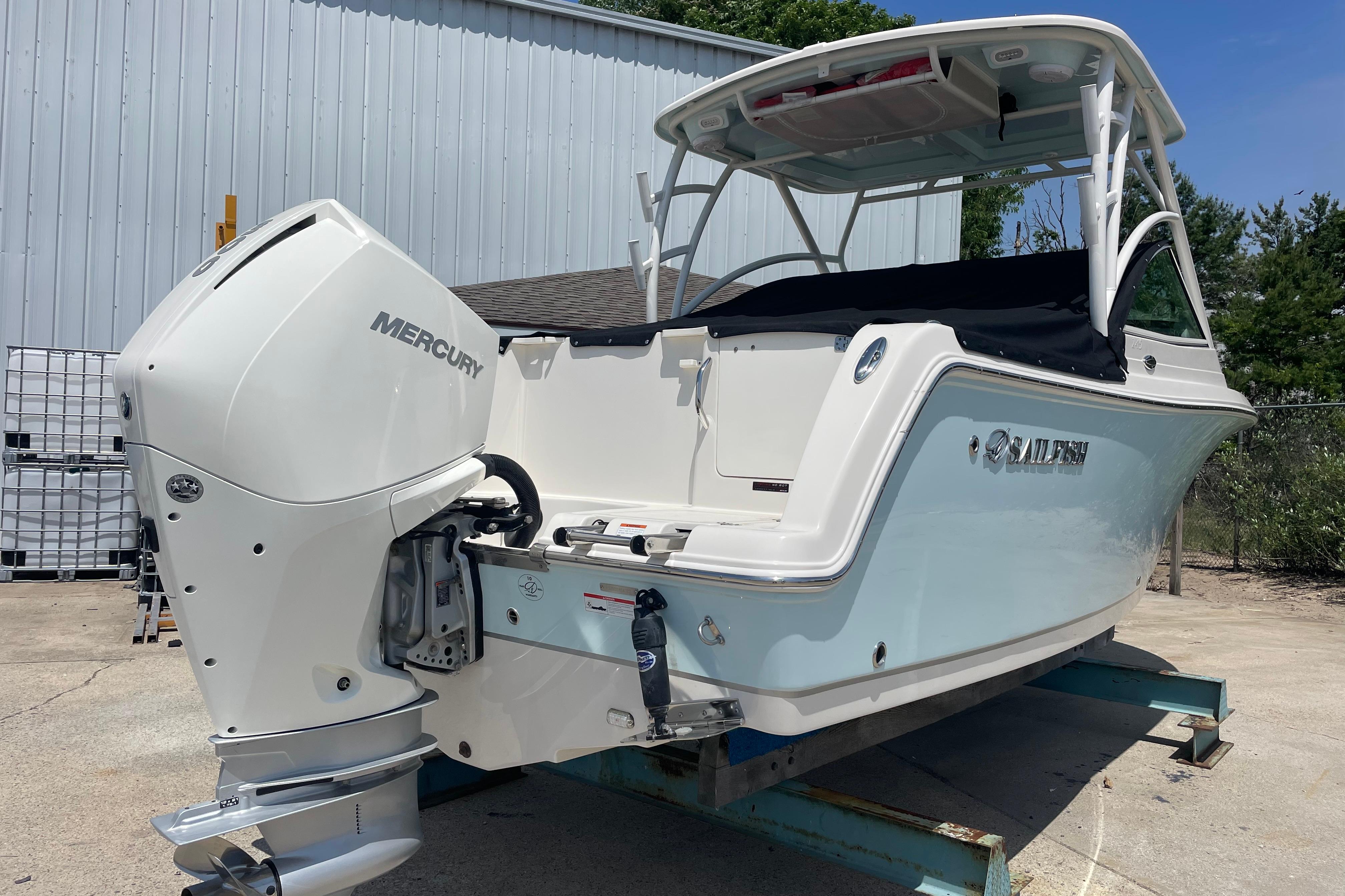 2022 Sailfish 245 DC boat with Mercury outboard engine, parked outdoors.