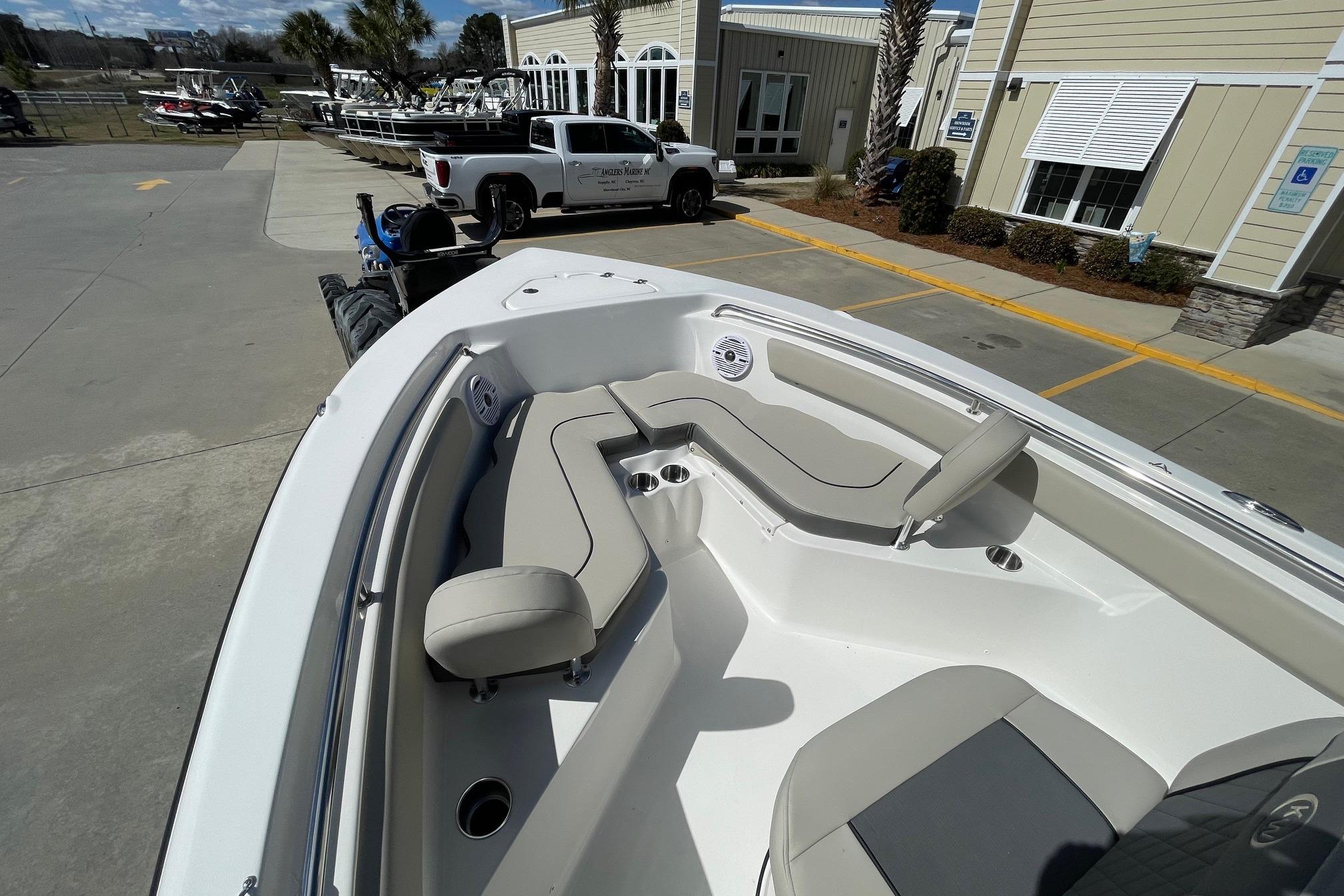 2026 Key West 203 FS boat with spacious seating, parked outdoors near a building.