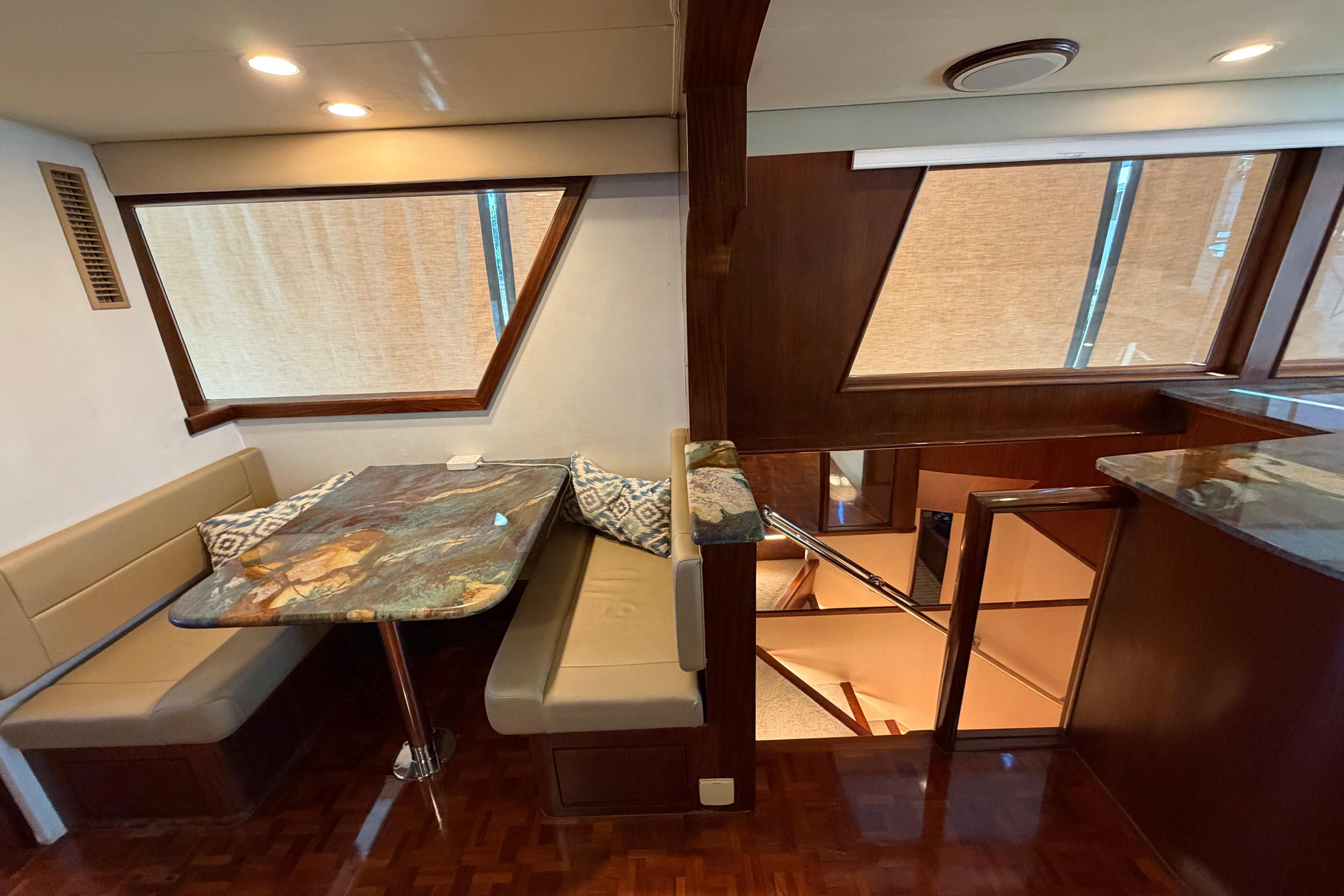 Interior of 1991 Hatteras 70 Motor Yacht with elegant dining area and wood accents.