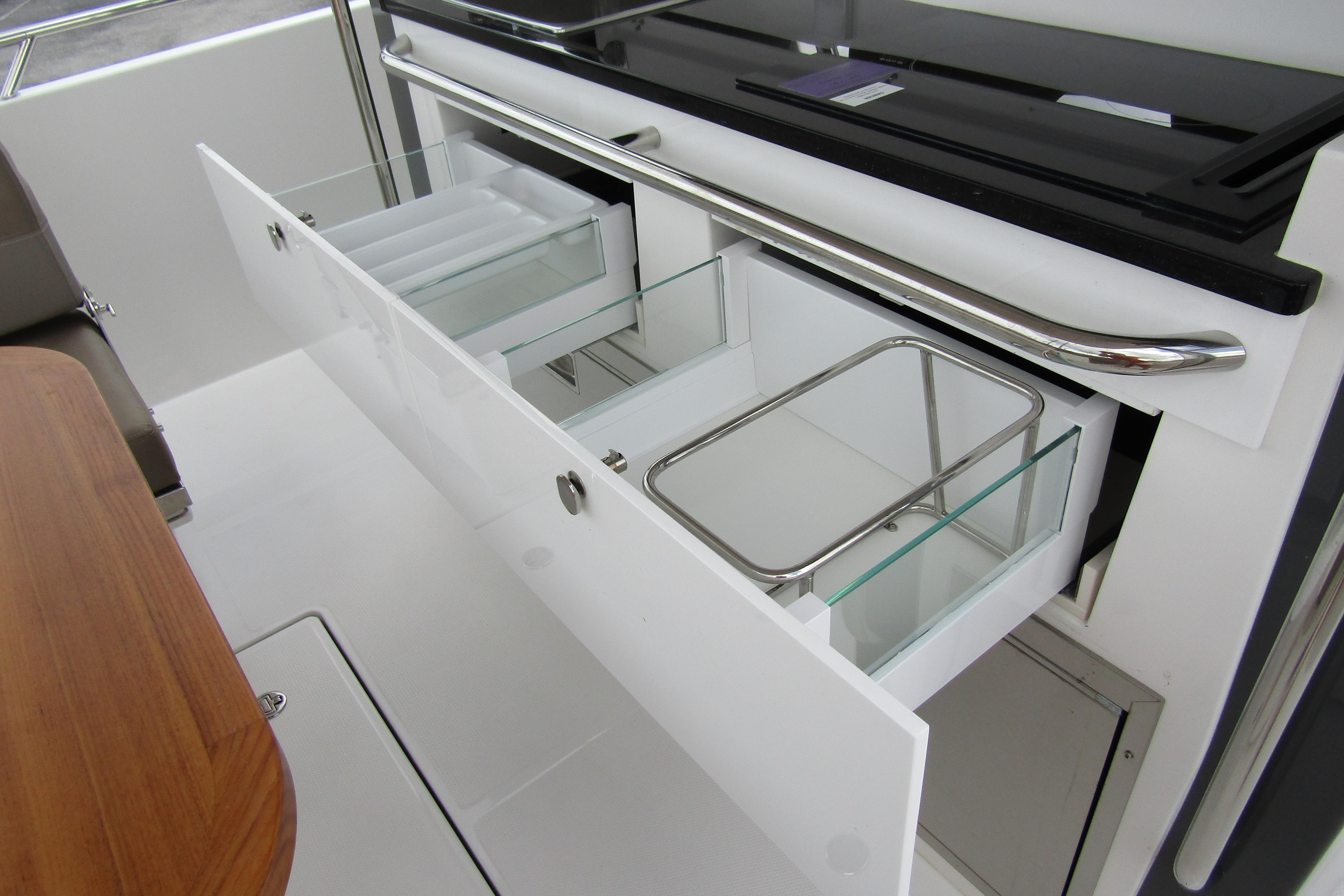 Open storage drawers on a 2025 Nimbus Tender 11 boat, showcasing sleek design.