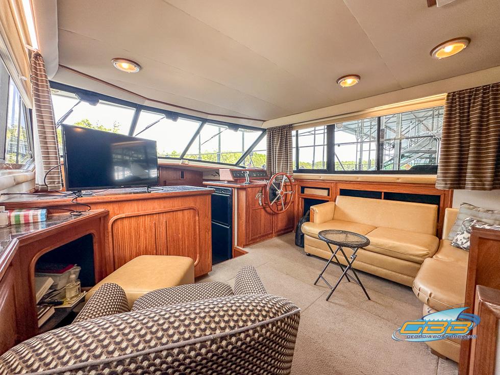1989 Carver 3807 Aft Cabin interior with seating, TV, and helm station.
