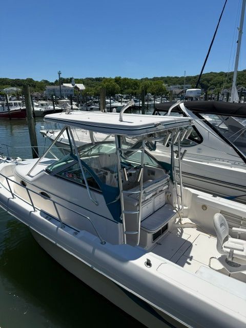 A 1995 Pro-Line 2950 Walkaround docked at a marina. It features a covered helm area.