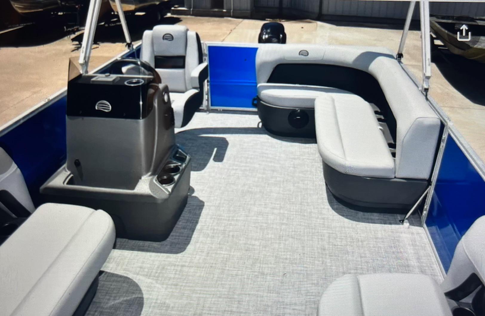 2026 Sun Tracker Party Barge 16 DLX interior with gray seating and helm.