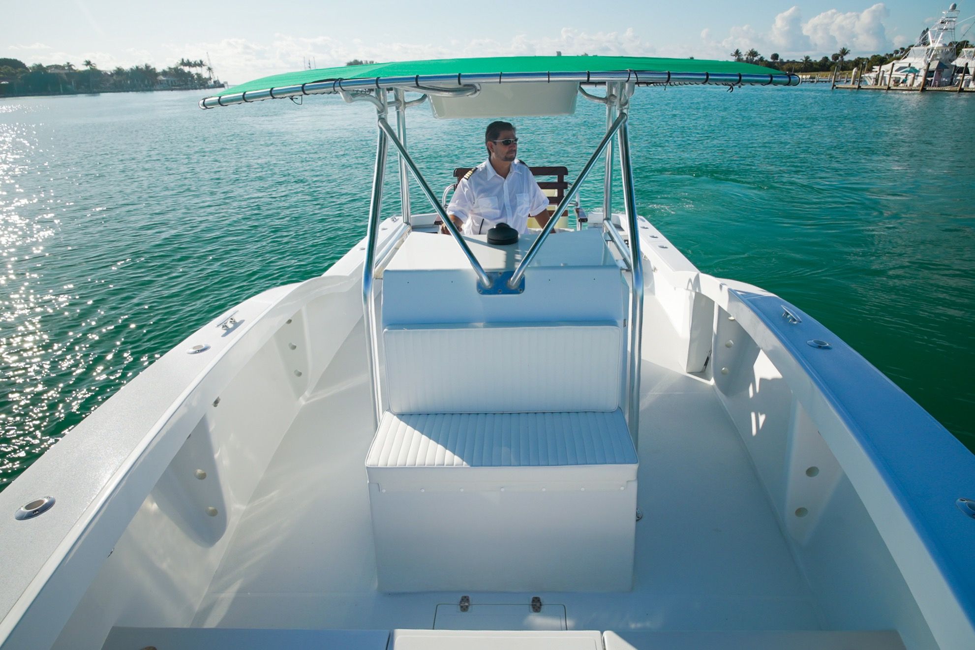 Man steering Ocean Master 28 boat on calm waters.