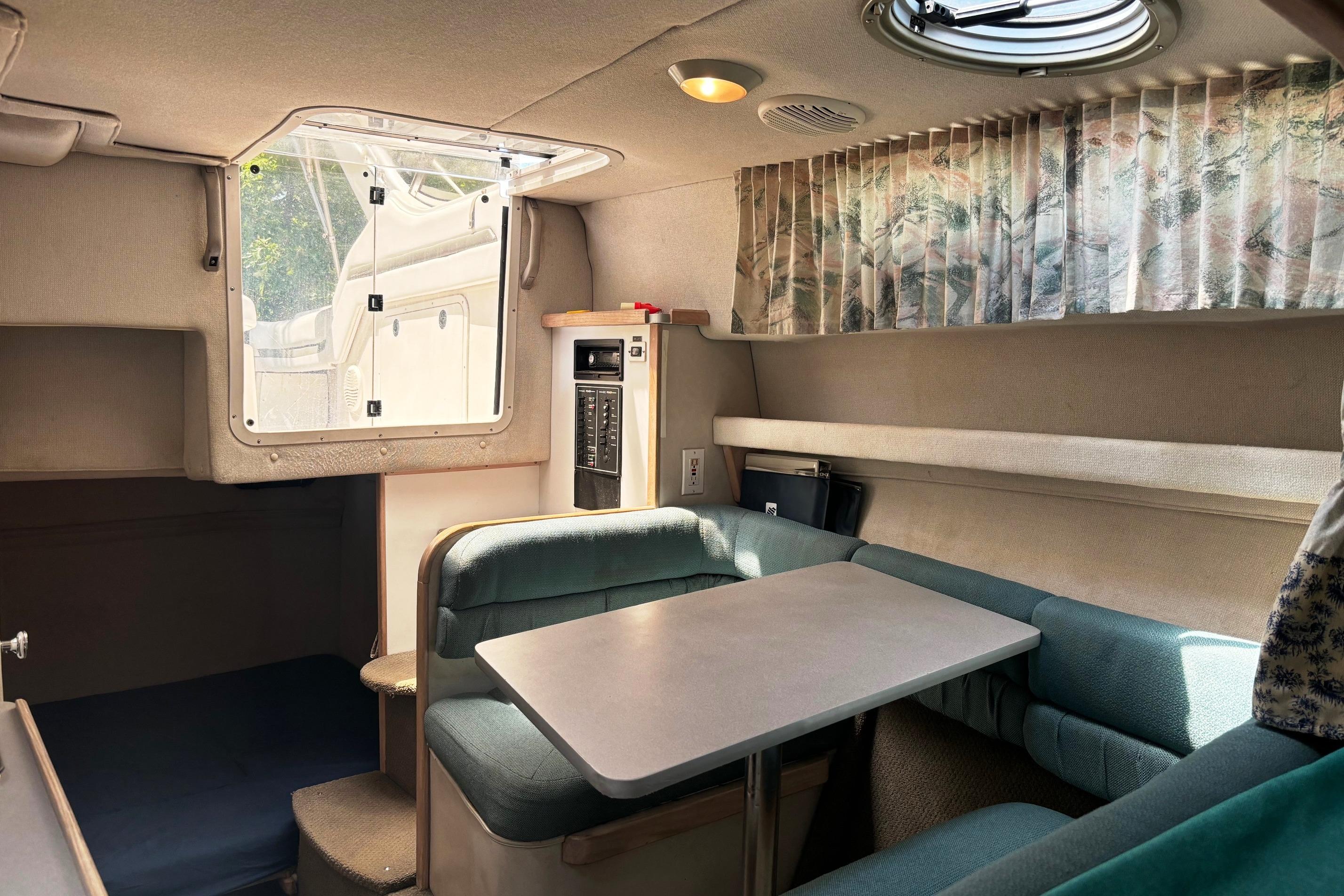 Interior of 1994 Four Winns 278 Vista boat with cozy seating and table.