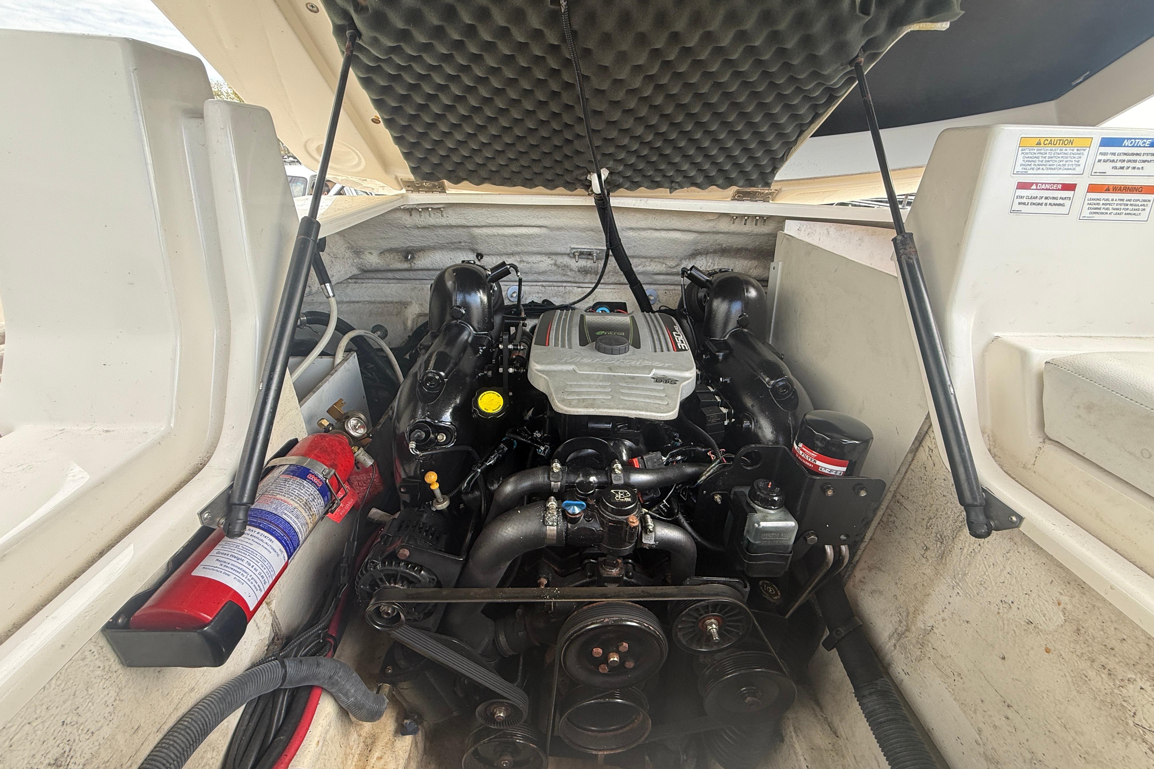 Engine compartment of a 2015 Sea Ray 240 Sundeck with visible fire extinguisher.
