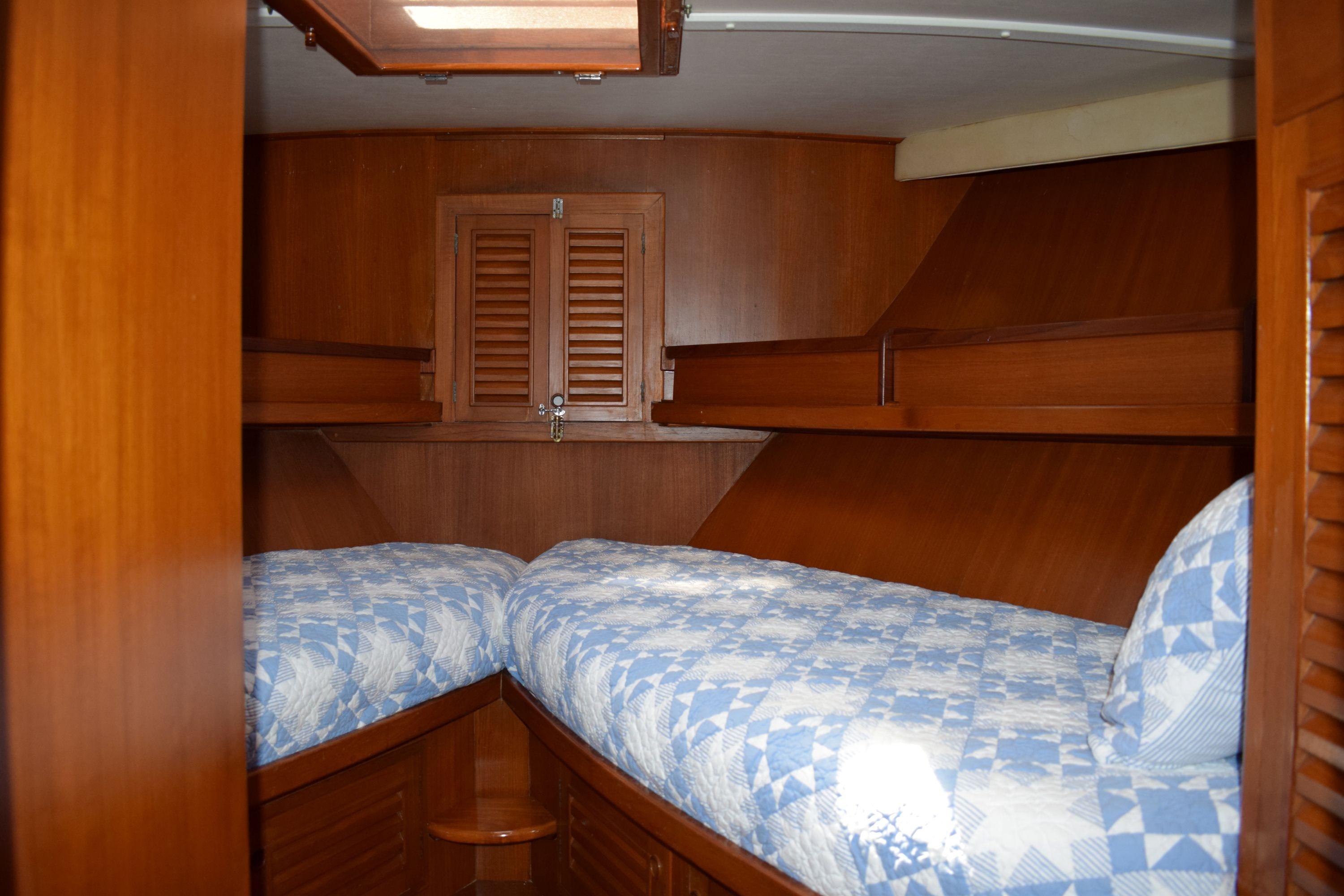 Interior cabin of 1980 Cheoy Lee 52 Motorsailer with twin beds and wooden finish.