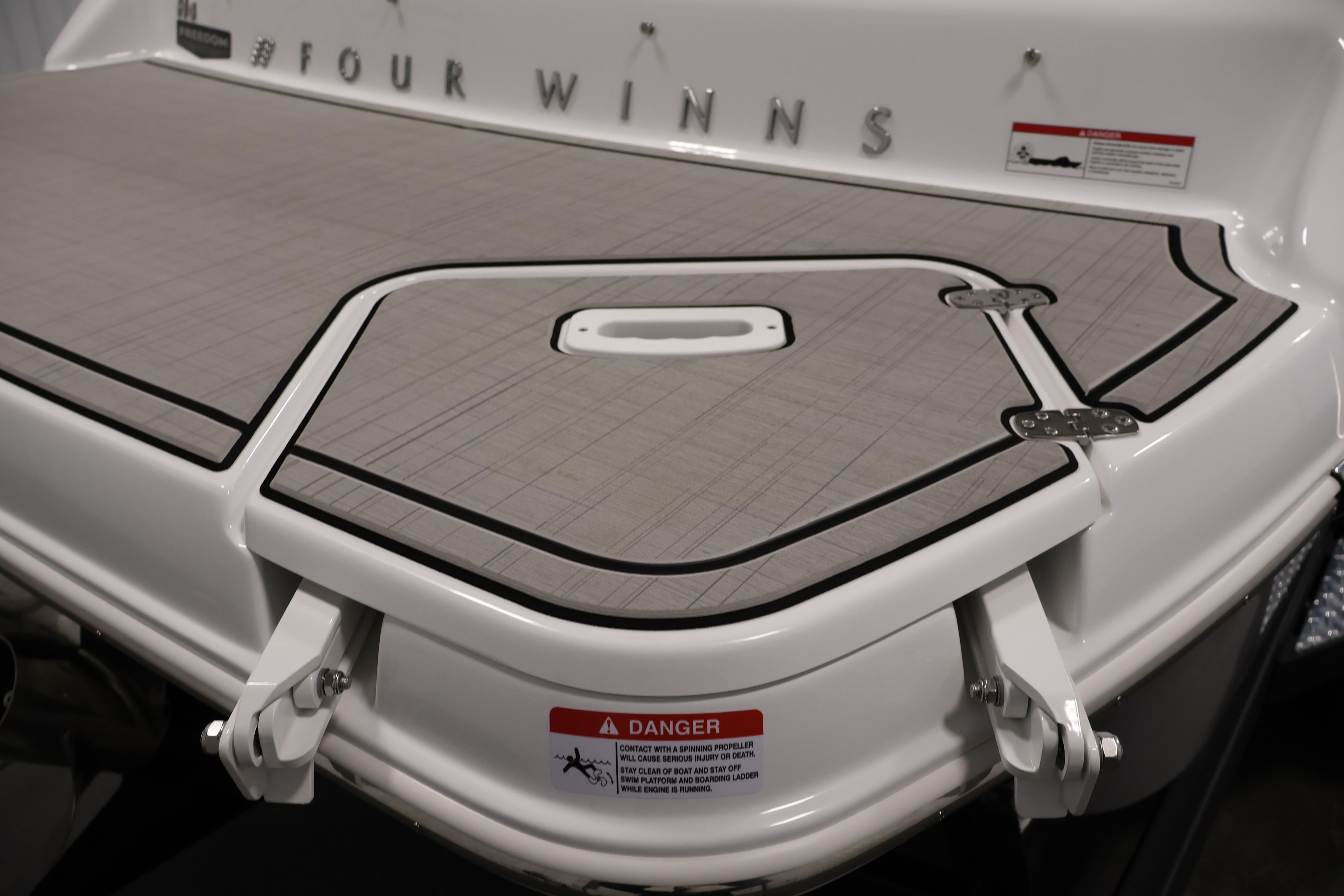 2026 Four Winns H4 Freedom boat swim platform with safety warning label.