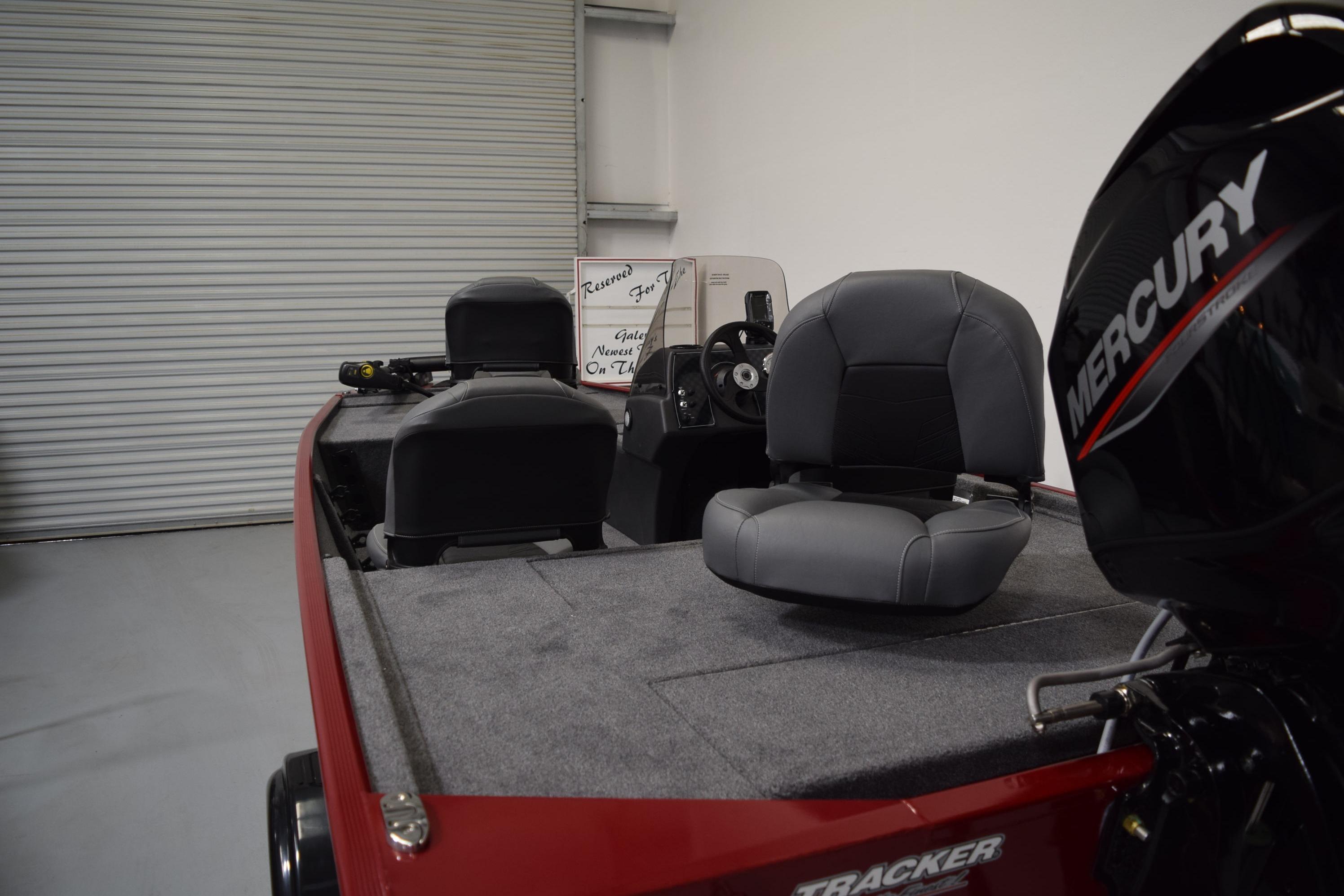 2026 Tracker Bass Tracker Classic XL boat interior with Mercury engine in a garage.
