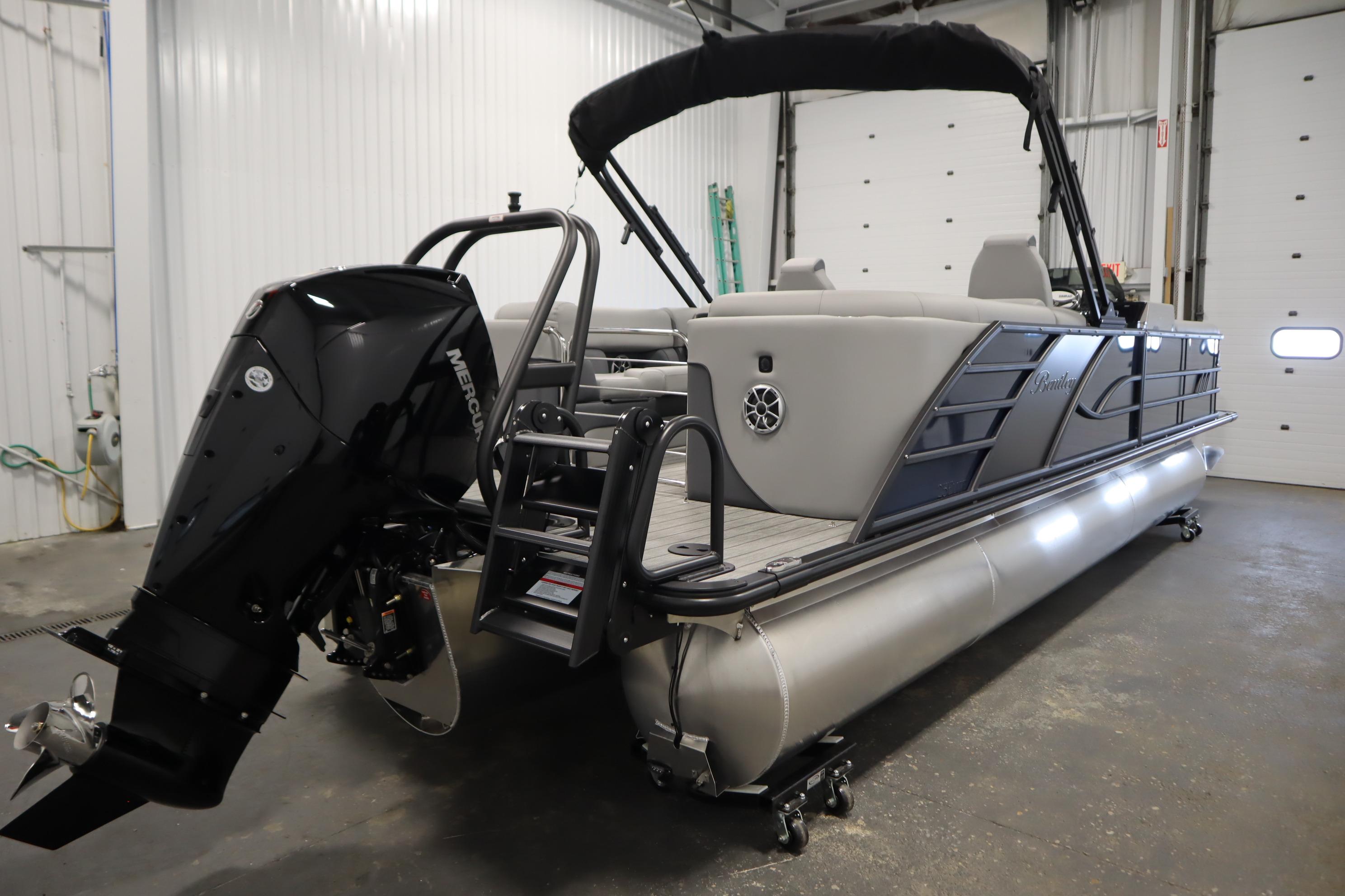 2025 Bentley Pontoons Elite 253 Admiral Tri-toon in a garage, featuring a Mercury outboard motor.