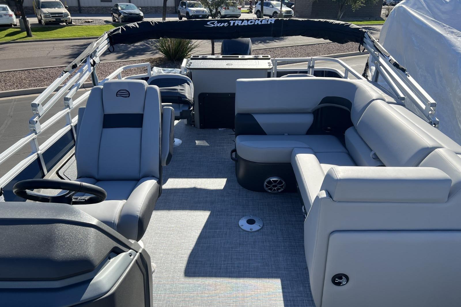 2026 Sun Tracker SportFish 22 DLX pontoon boat interior with gray seating and steering console.