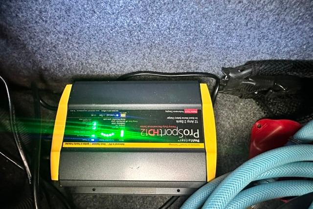 Battery charger in a 2021 Yamaha Boats 275SD, with visible cables and indicators.