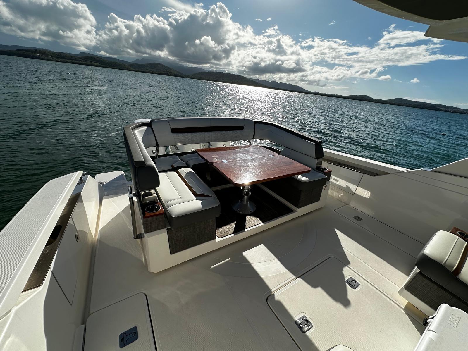 2020 Tiara Yachts 38 LS deck with seating and table, overlooking serene waters.
