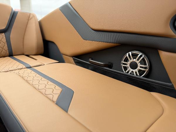 2025 Yamaha Boats 255XD interior with tan and black upholstery, featuring a built-in speaker.