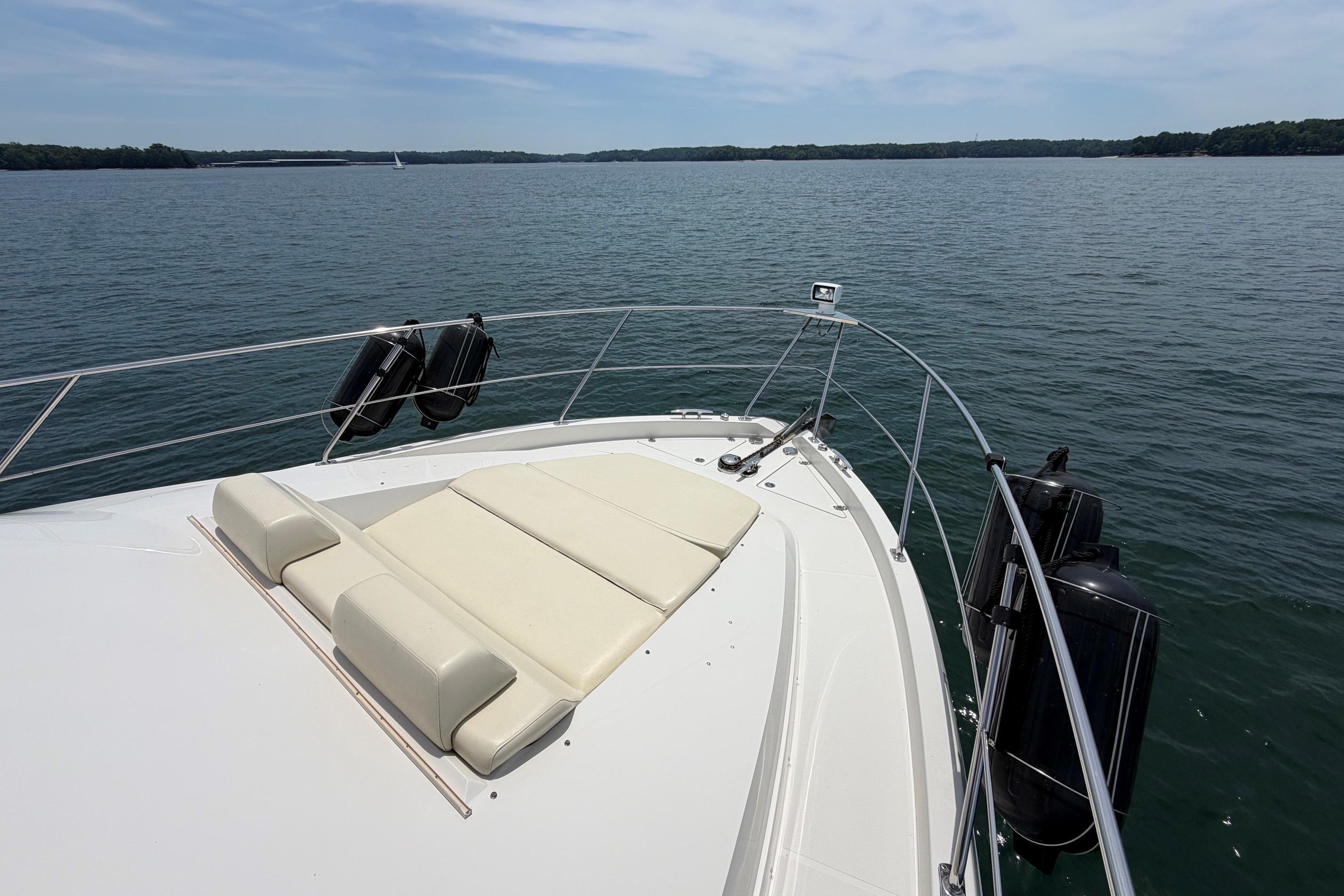 Bow view of 2011 Carver 44 Sojourn yacht on a serene lake.
