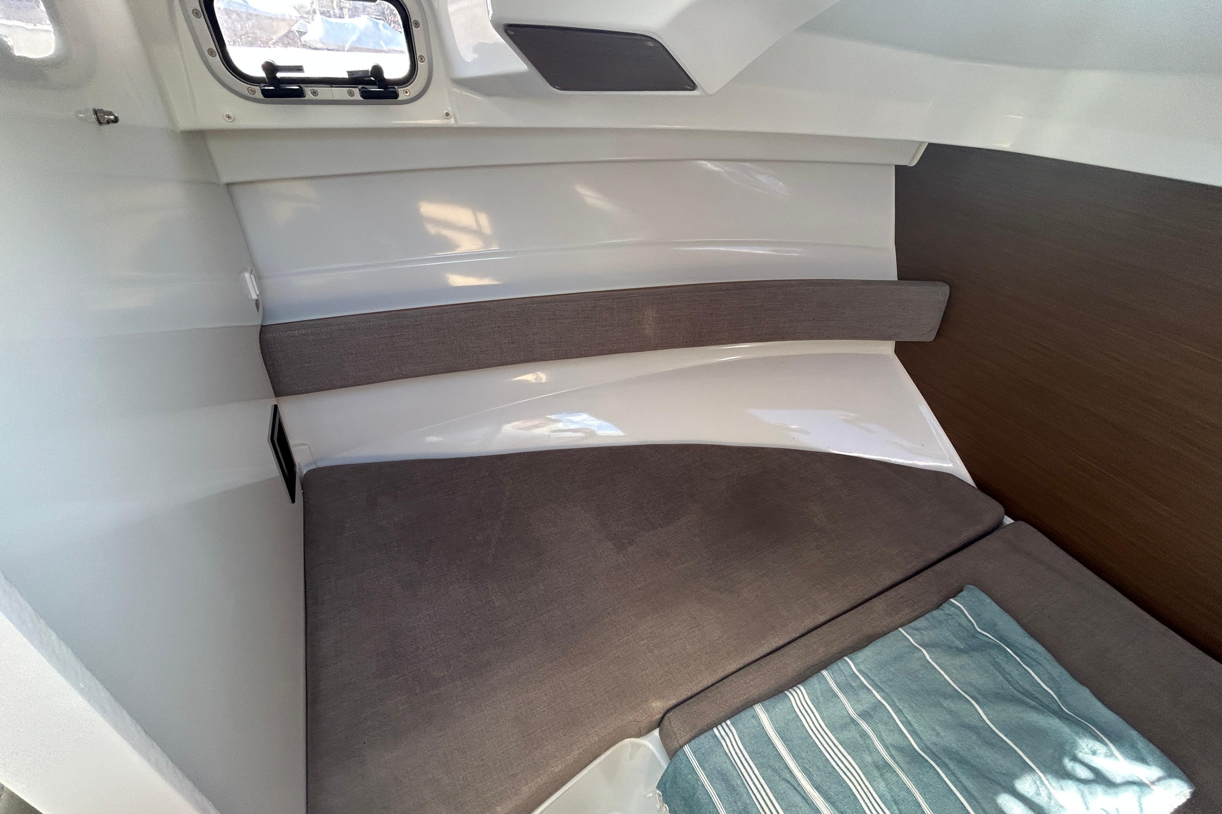Interior cabin of 2021 Beneteau Antares 8 with cozy seating and window.