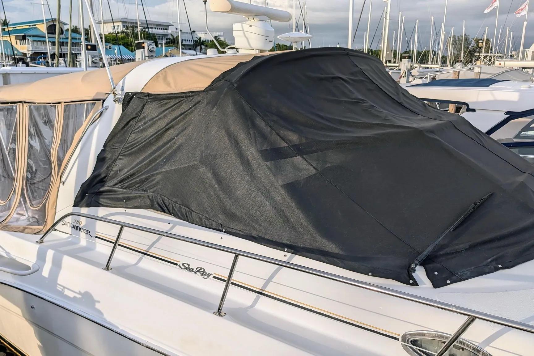 2000 Sea Ray 380 Sundancer yacht with black cover docked at marina.