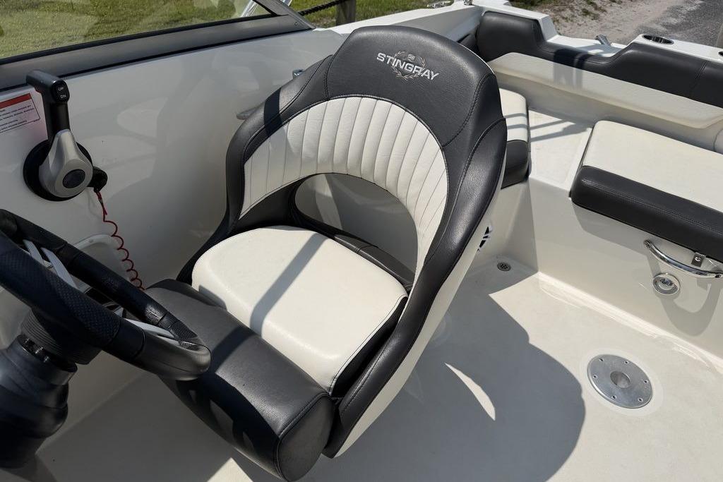 Captain's seat of a 2019 Stingray 201 DS boat, featuring black and white upholstery.