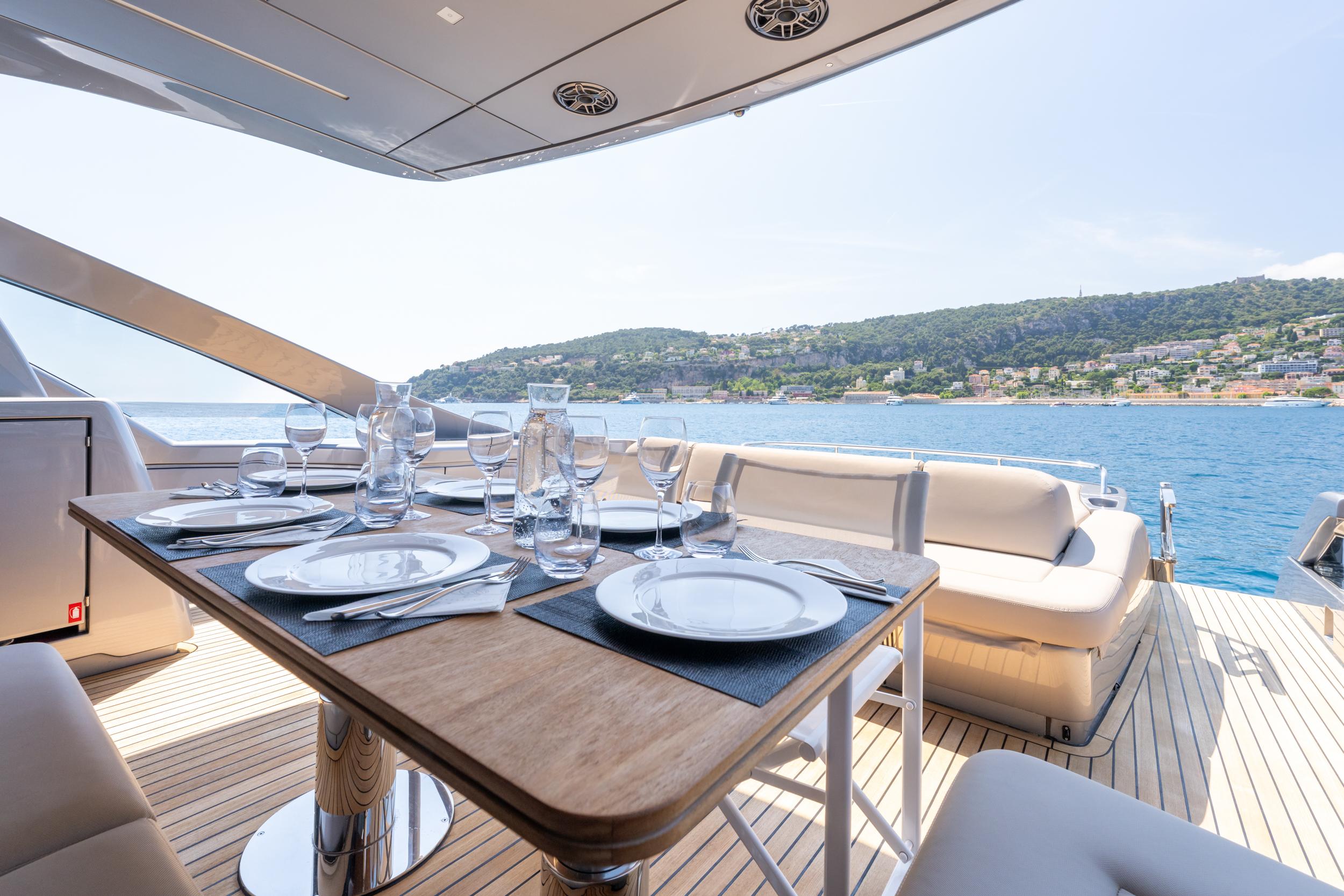 Luxurious dining setup on 2024 Pershing 7X yacht with scenic ocean view.