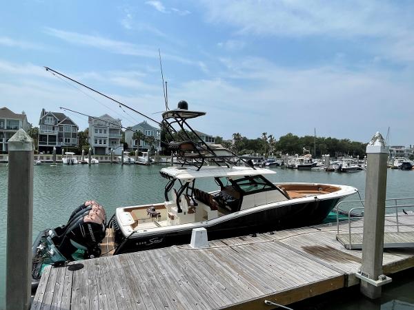 2020 Scout 420 LXF boat docked at marina with scenic waterfront view.