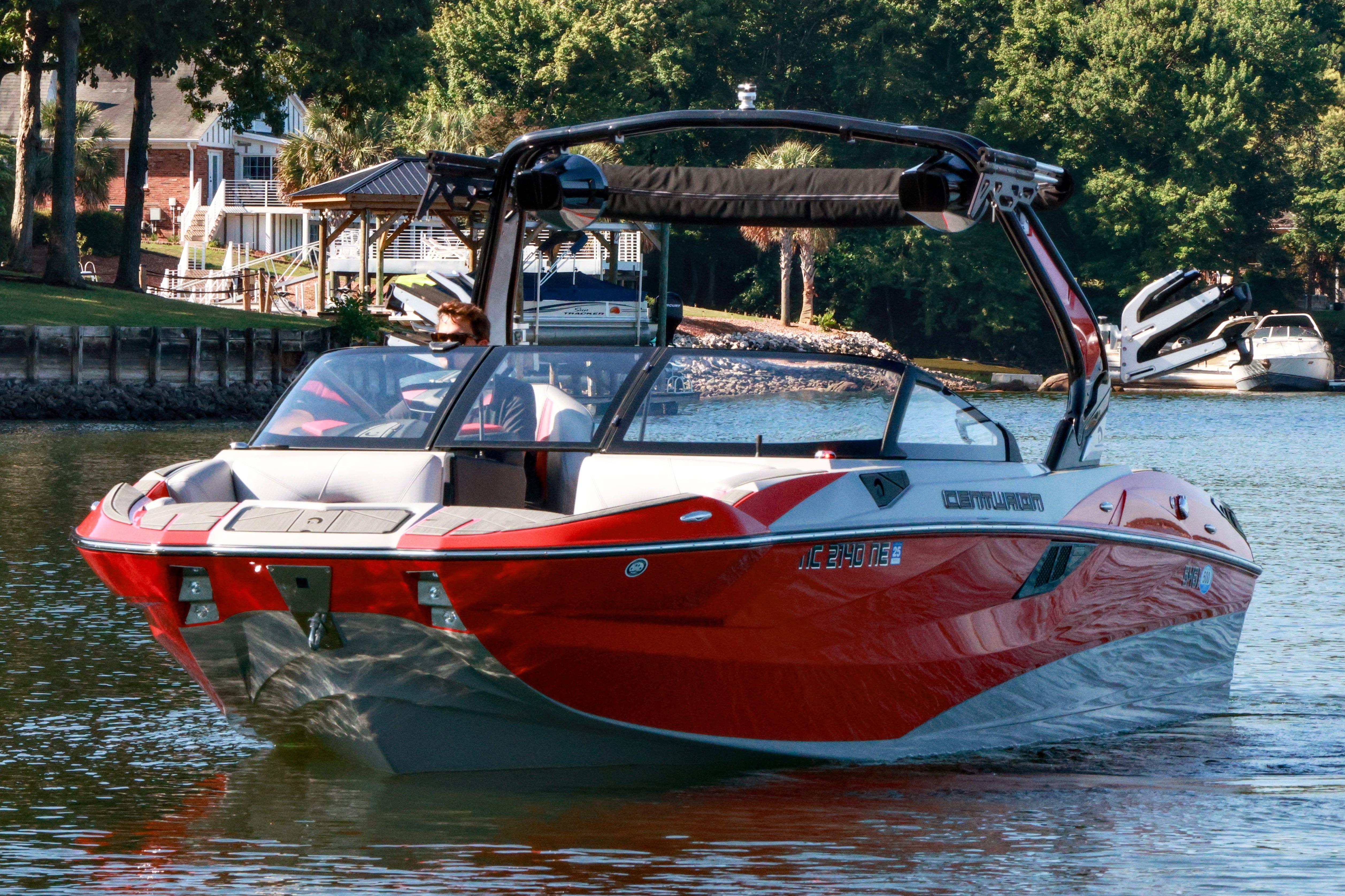 2024 Centurion Fi23 boat cruising on a scenic lake with lush greenery.