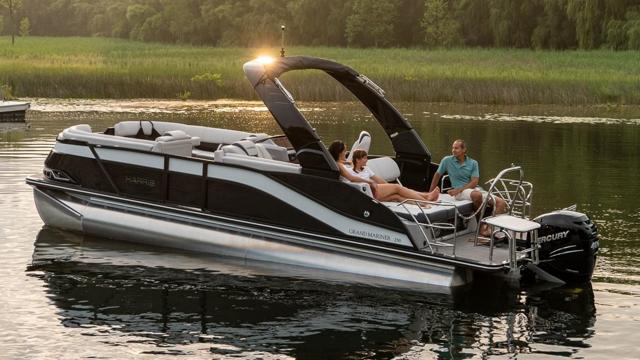 2024 Harris FloteBote 250 Grand Mariner V10 400 pontoon boat on a serene lake.