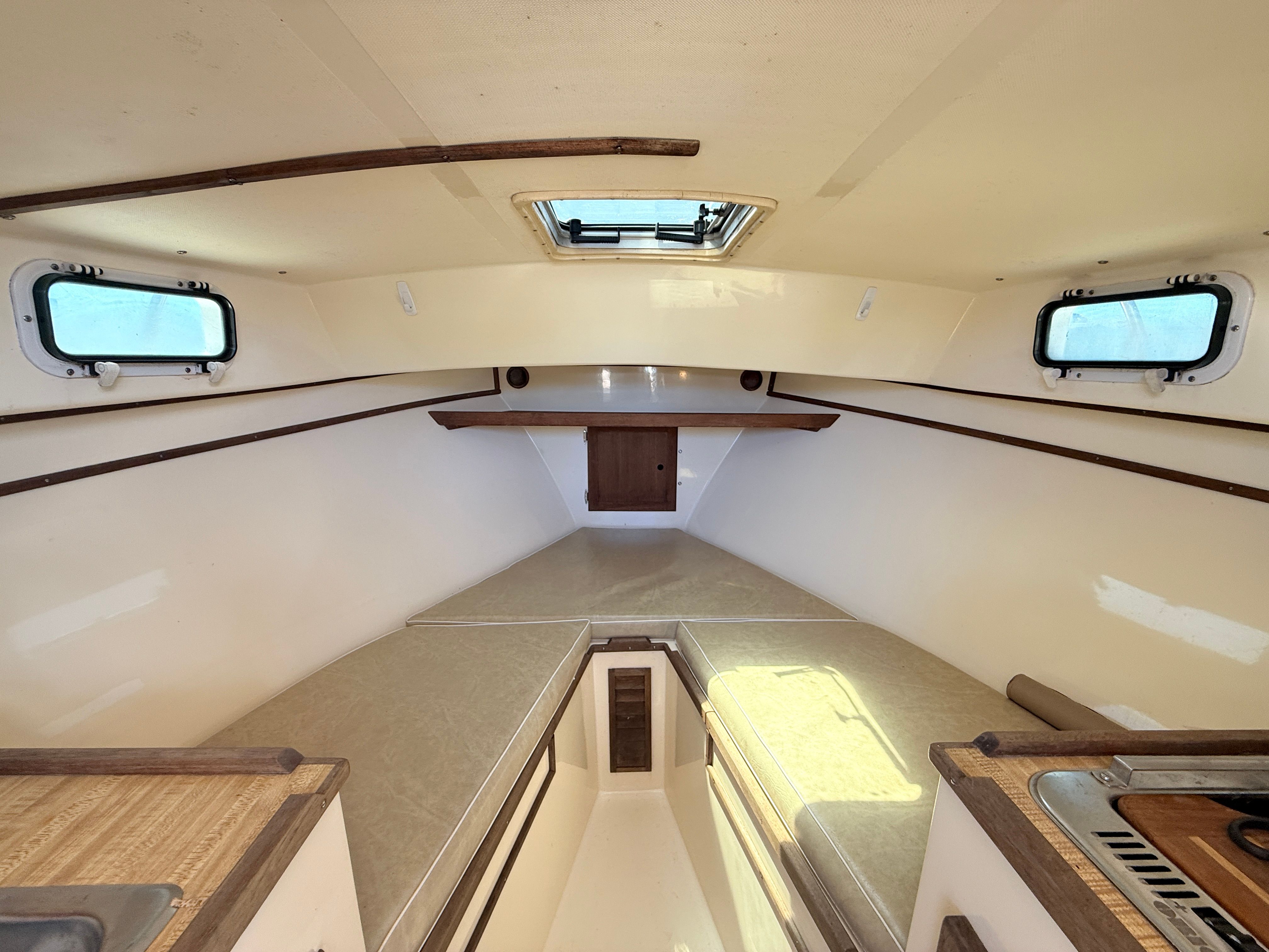 Interior of a 1989 Fortier 26 with wood accents and windows.