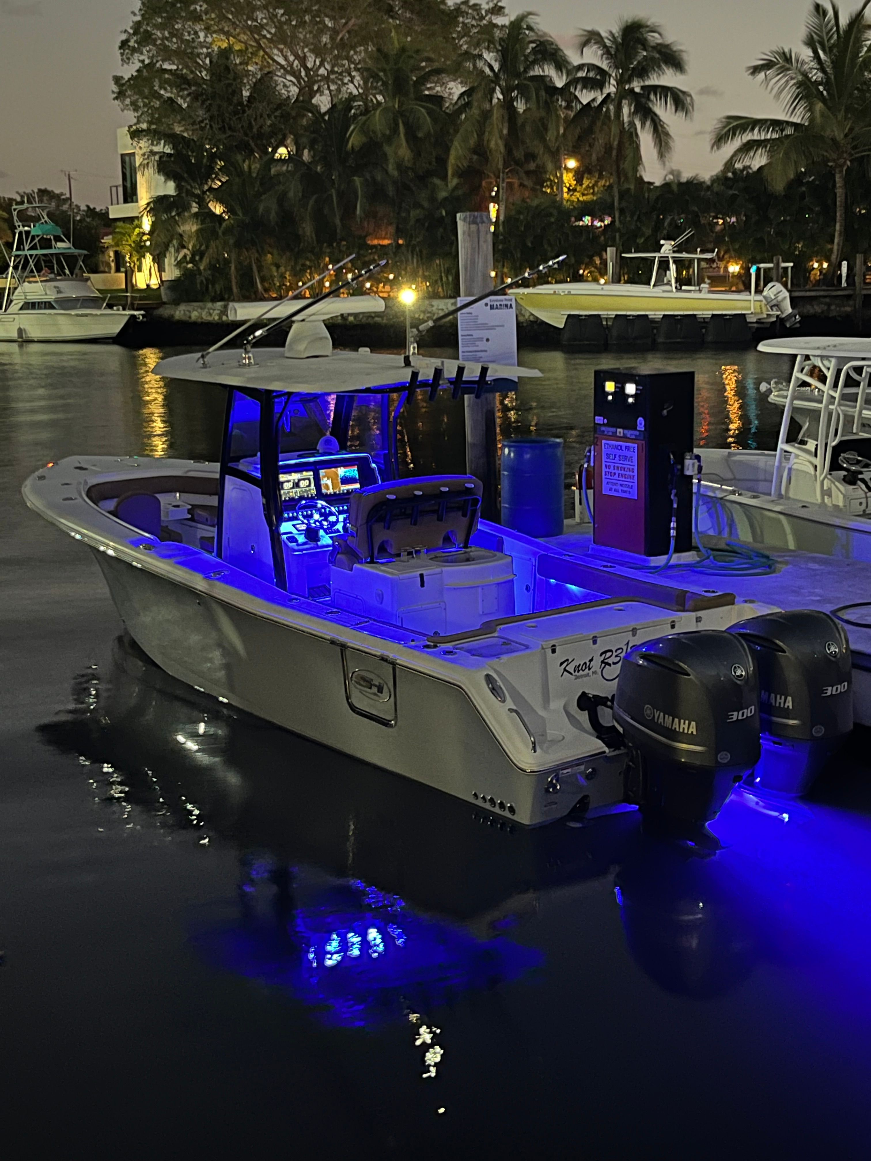 A Sea Hunt Gamefish 30 boat with blue lighting is on the water at night.