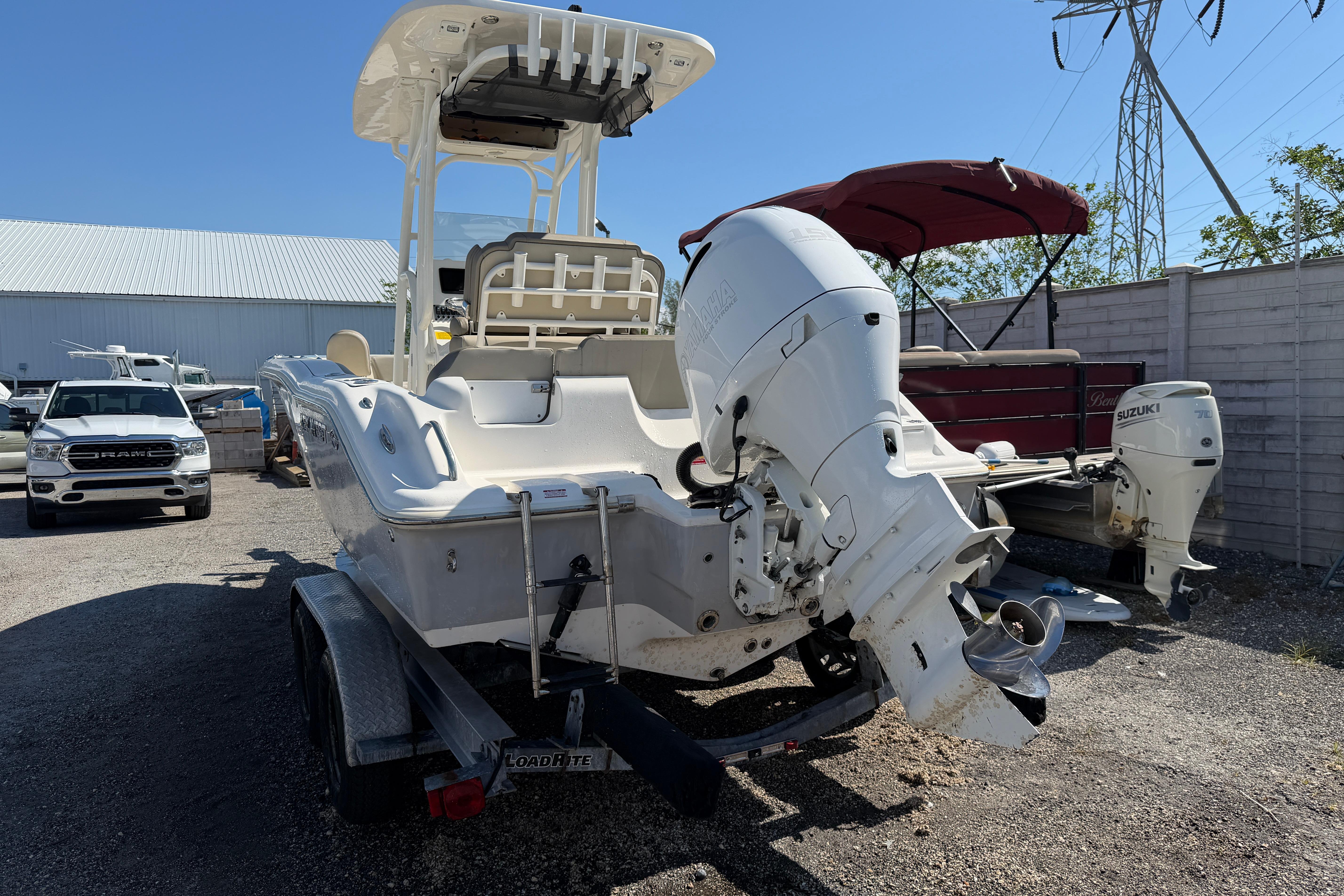 2022 Key West 219 FS boat on trailer with outboard motor in a yard.