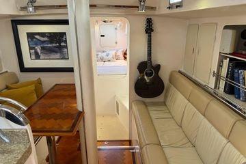 Interior of 2011 Reliance 44 yacht with cozy seating, guitar, and framed artwork.