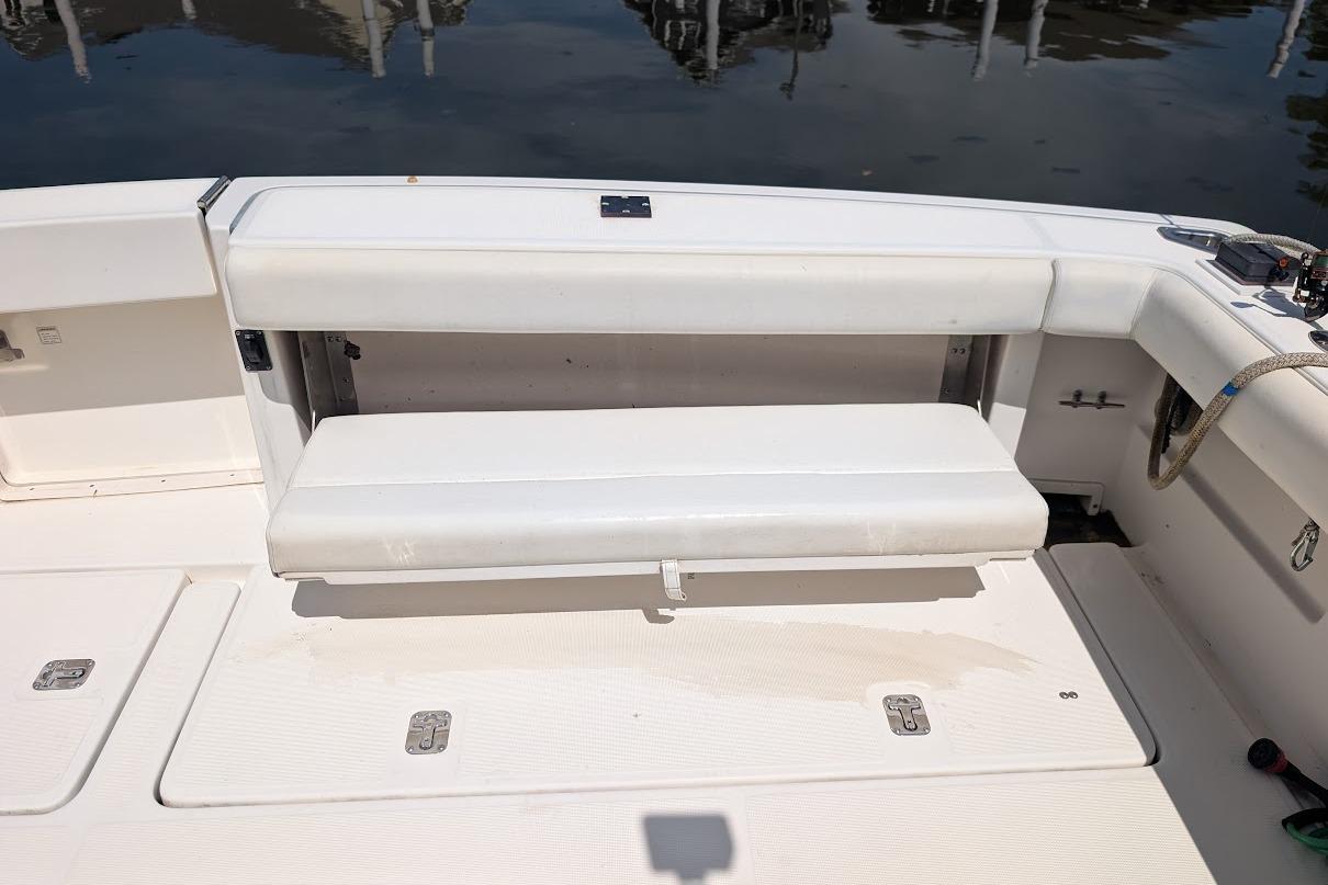 2000 Pursuit 3400 Express boat with white cushioned seating and deck, docked by water.
