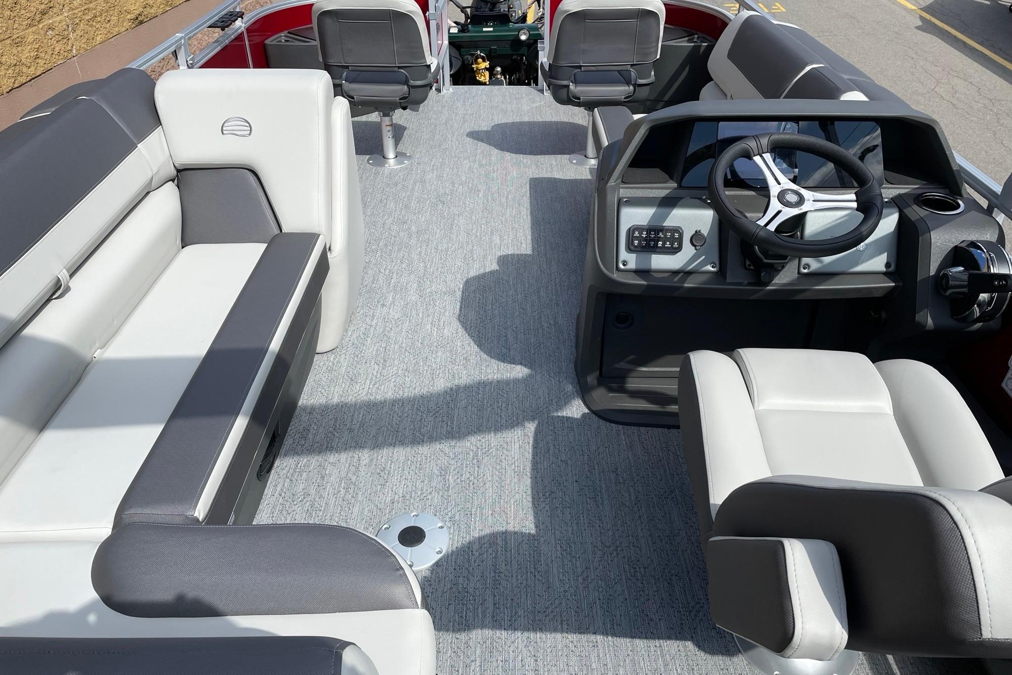 Interior of 2026 Sun Tracker Fishin' Barge 22 DLX with seating and steering console.
