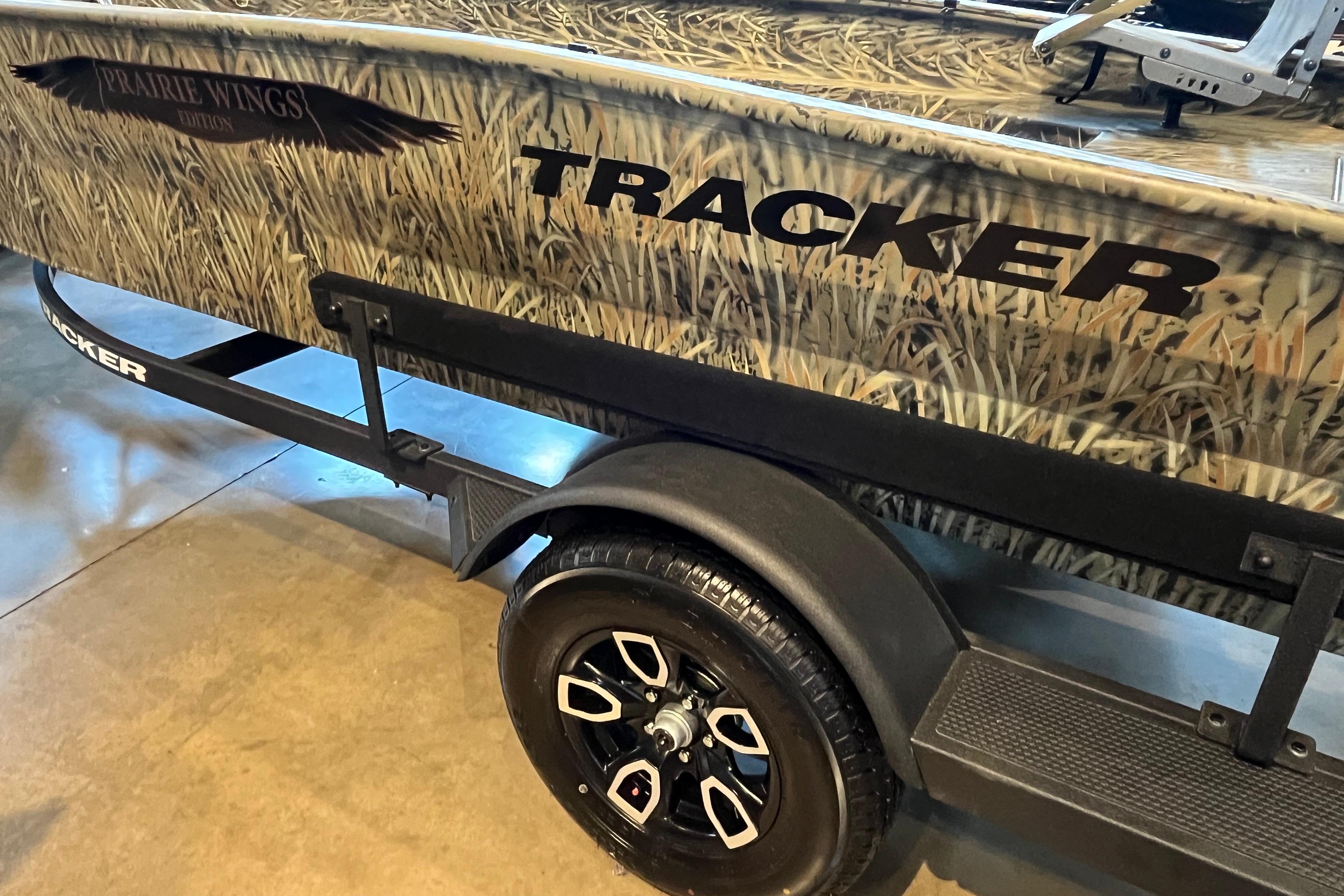 2026 Tracker Grizzly 1650 T Prairie Wings Edition boat with camouflage design and black trailer.