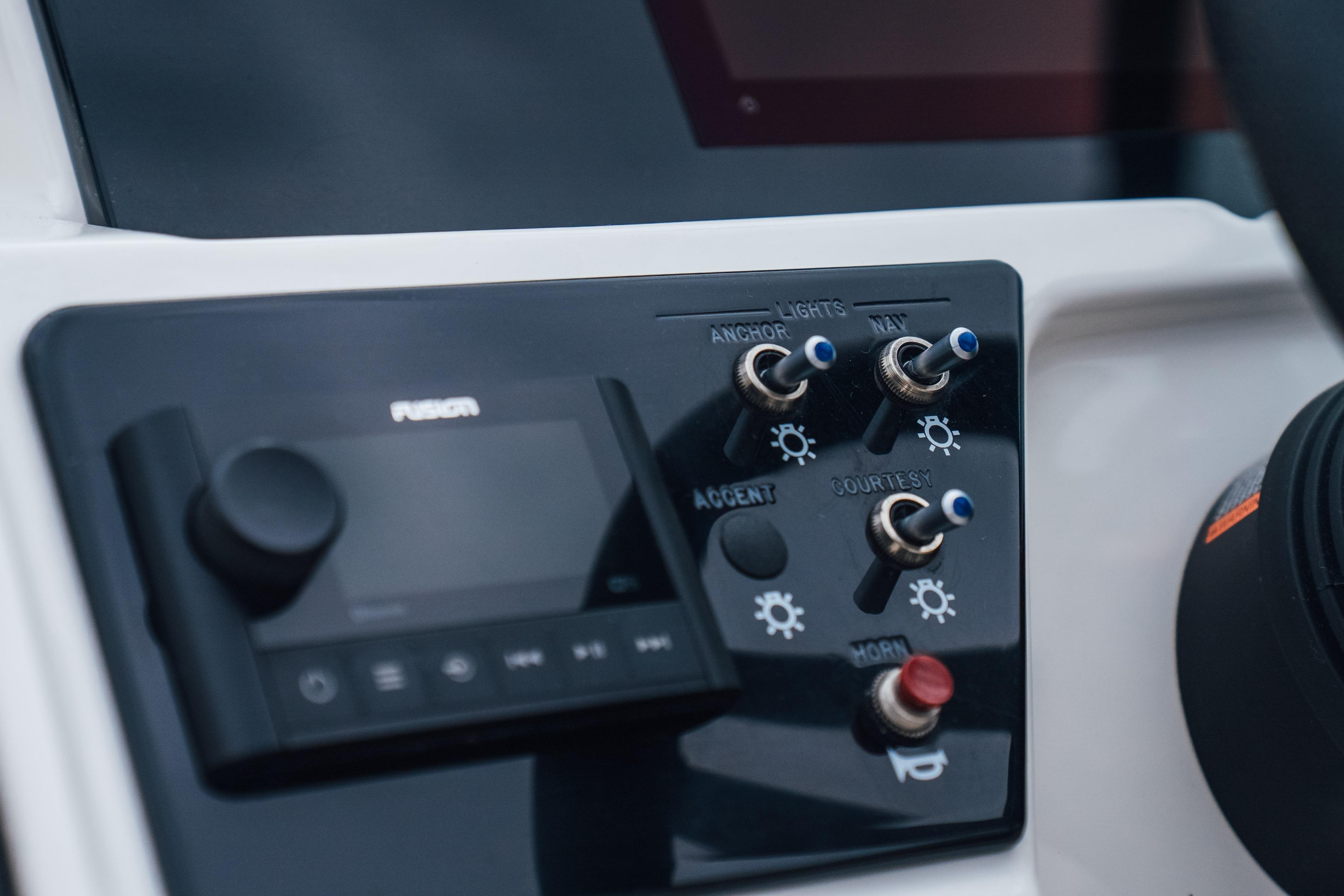 Control panel of 2023 Sea Ray SPX 230 boat with switches and audio system.