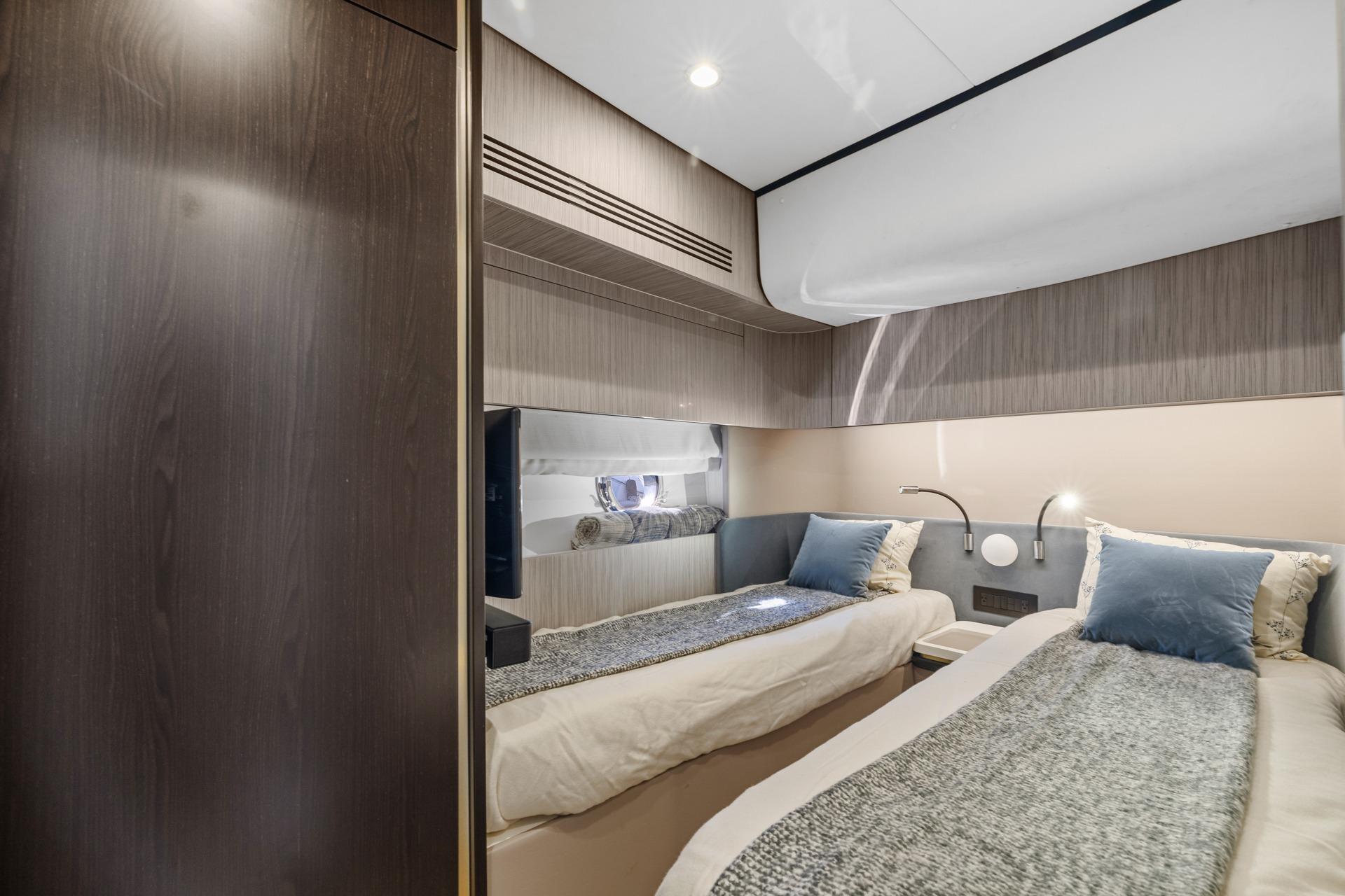 Luxurious 2019 Azimut 55 yacht cabin with twin beds and modern decor.