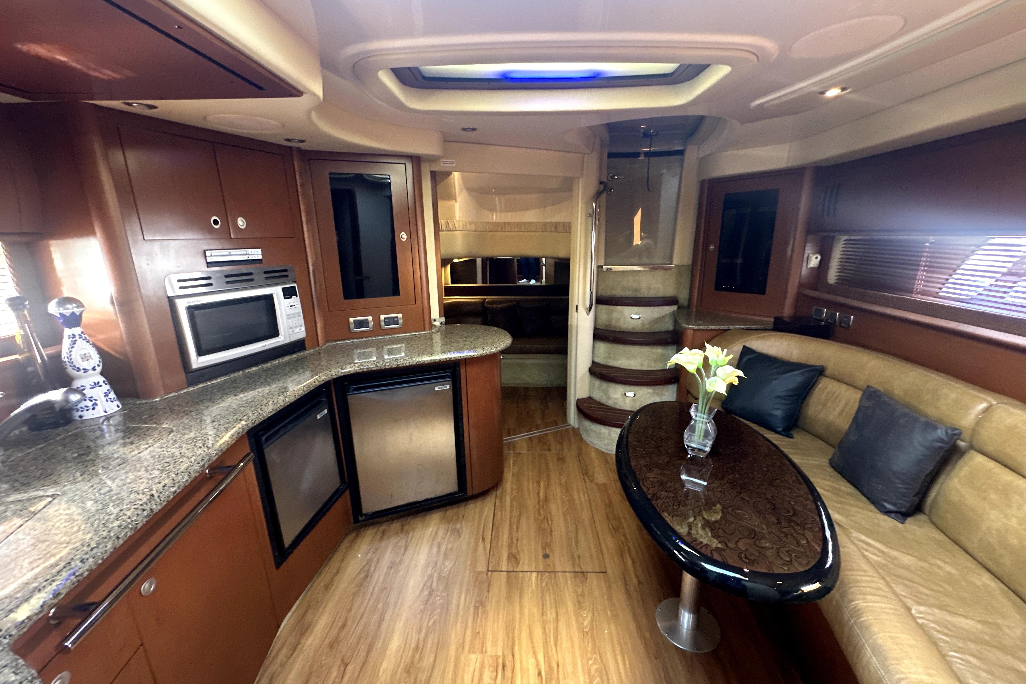 Luxurious interior of a 2007 Sea Ray 44 Sundancer yacht with modern kitchen and seating area.