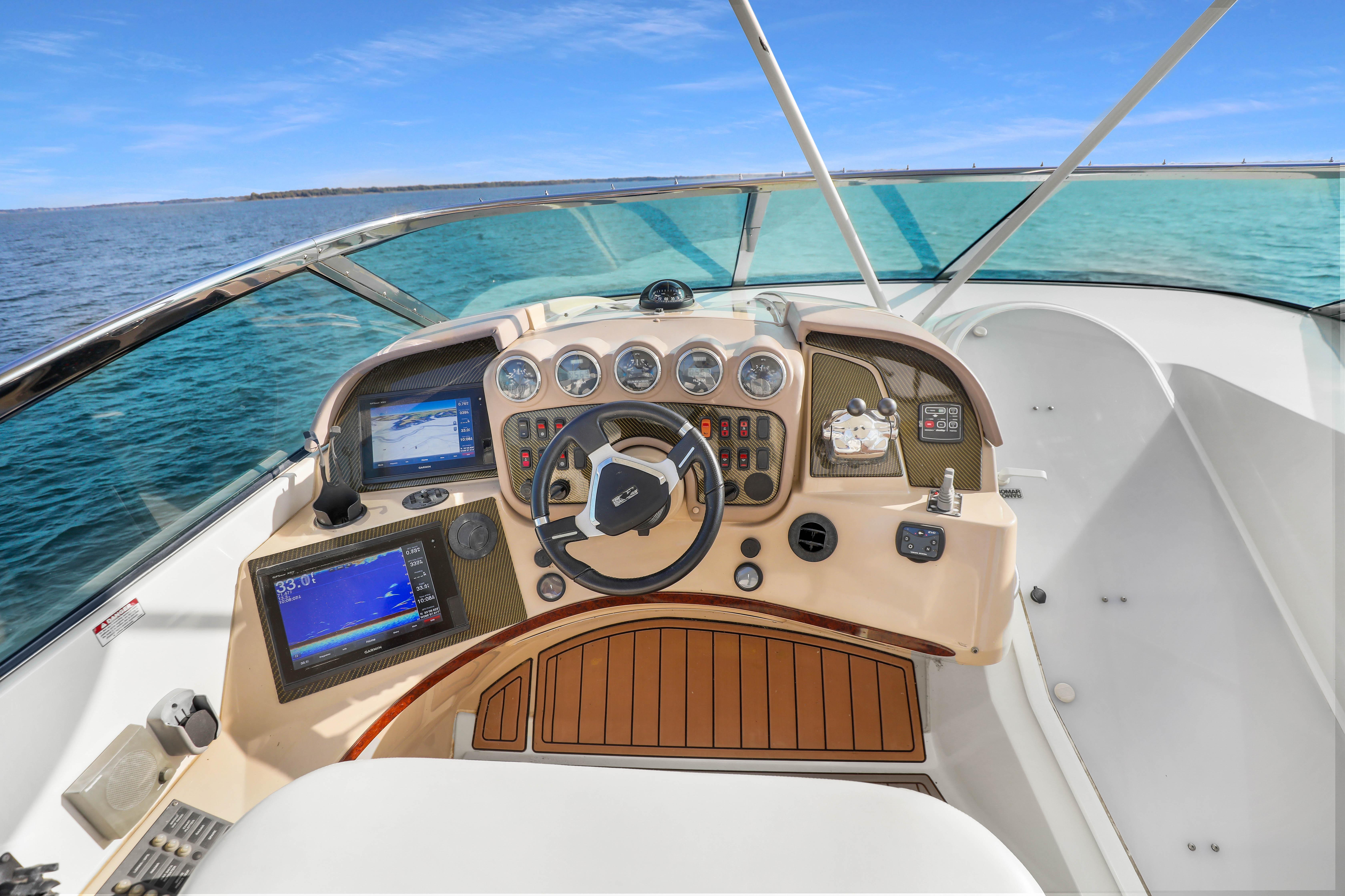 2005 Carver 560 Voyager helm with navigation displays, steering wheel, and ocean view.