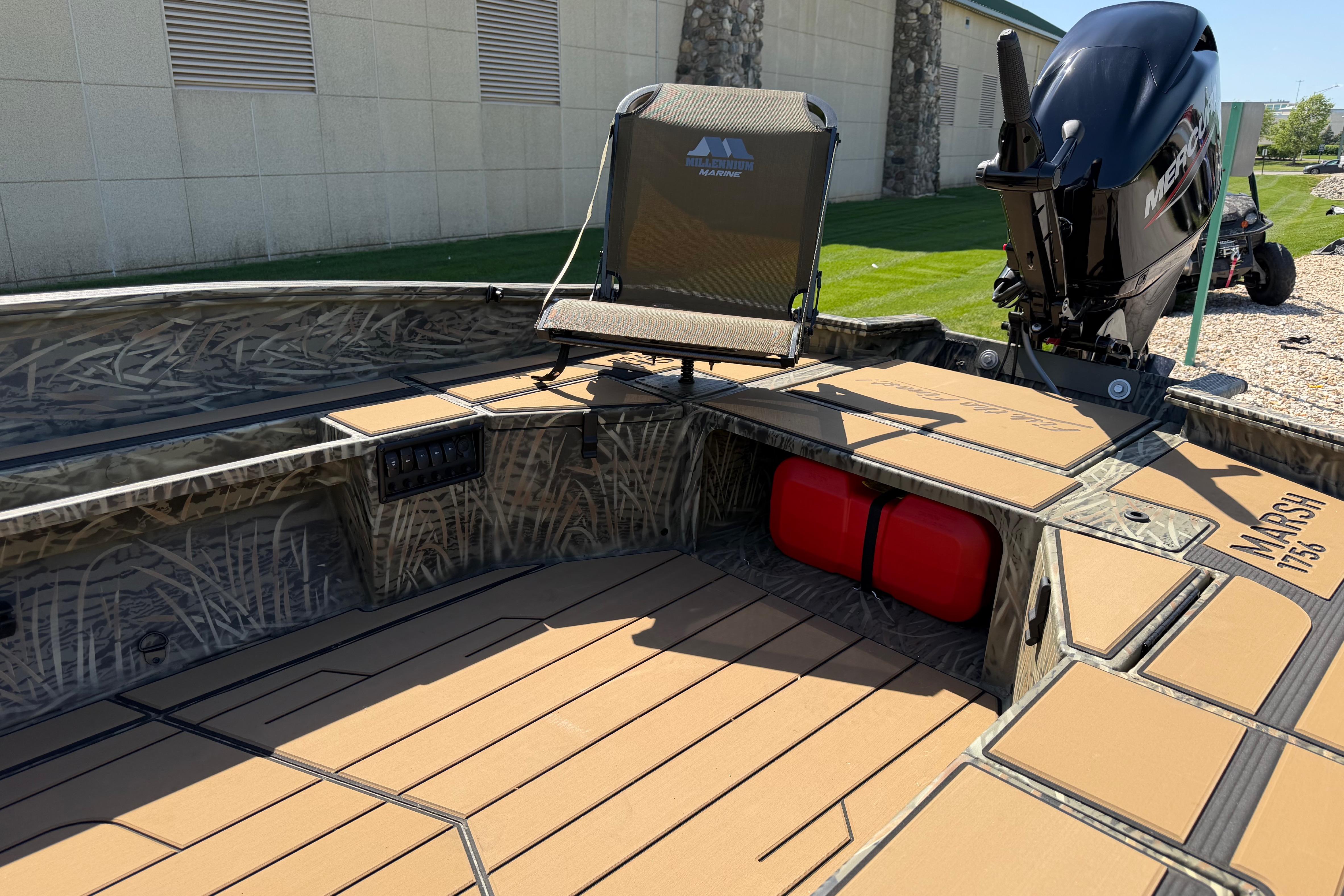 2026 Tracker Grizzly 1756 T Marsh boat interior with seating and engine, parked outdoors.