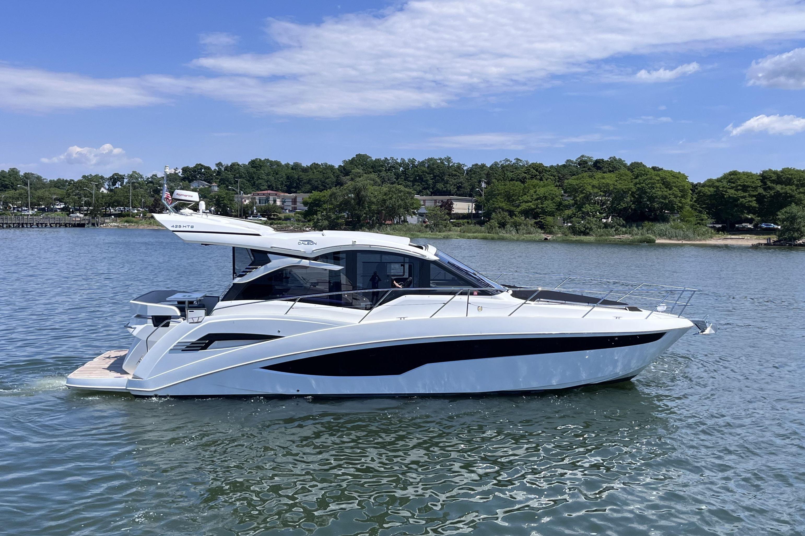 2024 Galeon 425 HTS yacht cruising on a serene lake under a clear blue sky.