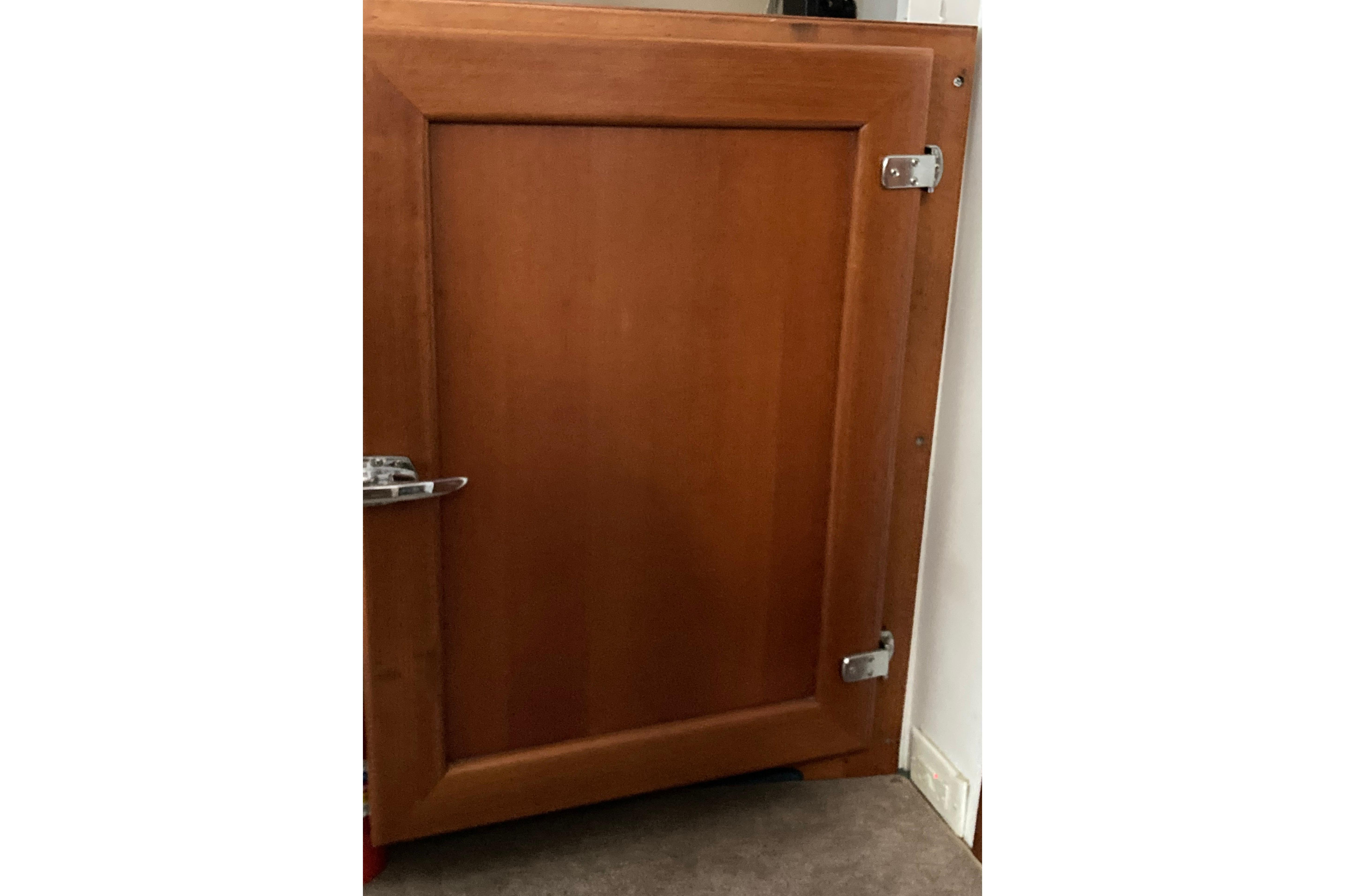 Wooden cabinet door with metal hinges, part of a 1942 Grenfell 42 Custom model.