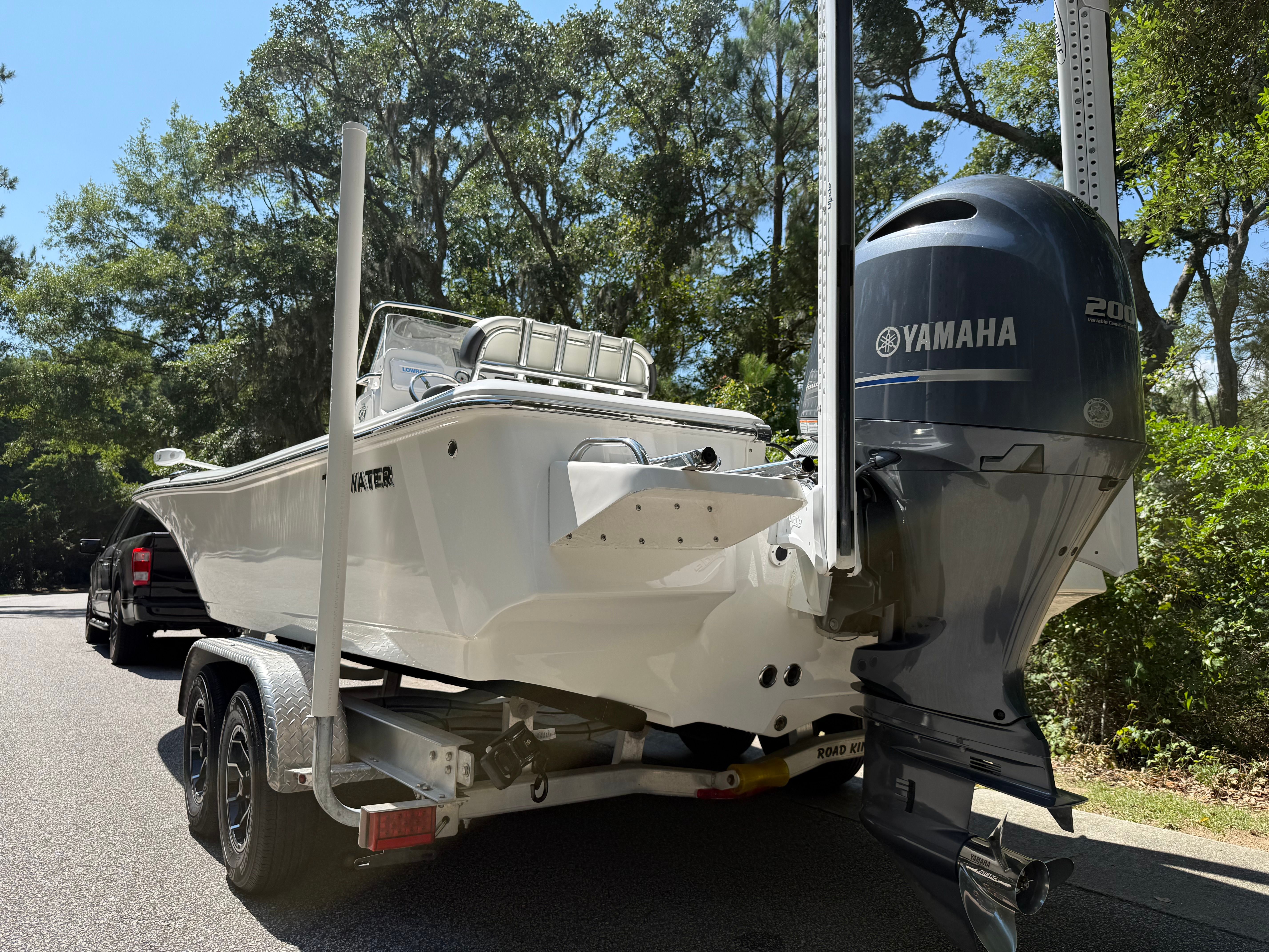 A white Tidewater 2210 Carolina Bay boat on a trailer with a Yamaha outboard motor.