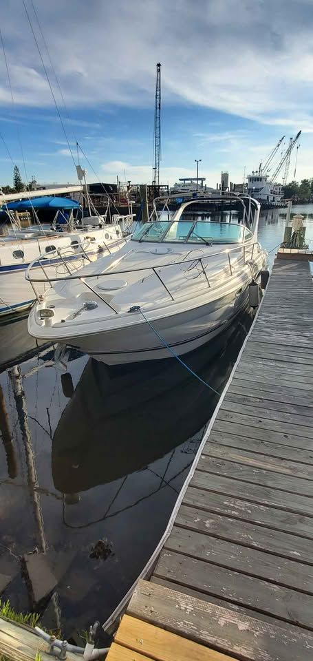 A 2002 Wellcraft 3300 Martinique docked at a wooden pier in a marina.