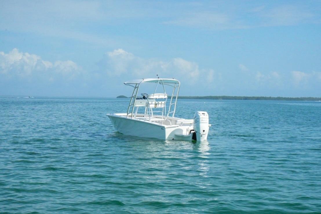 White 2016 Rambo 27 boat floating on calm blue ocean waters.