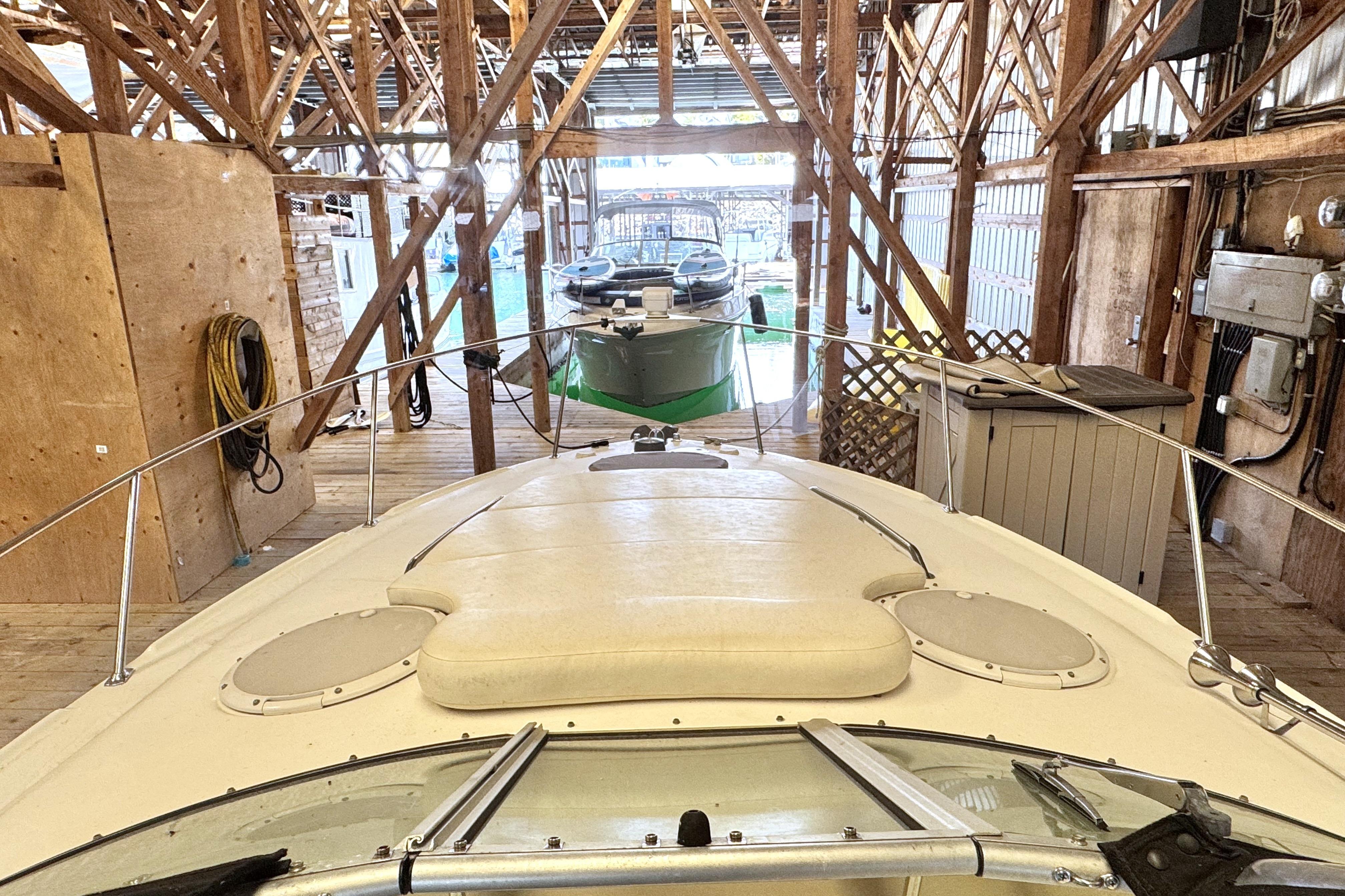 2002 Larson Cabrio 310 boat docked in a wooden marina.