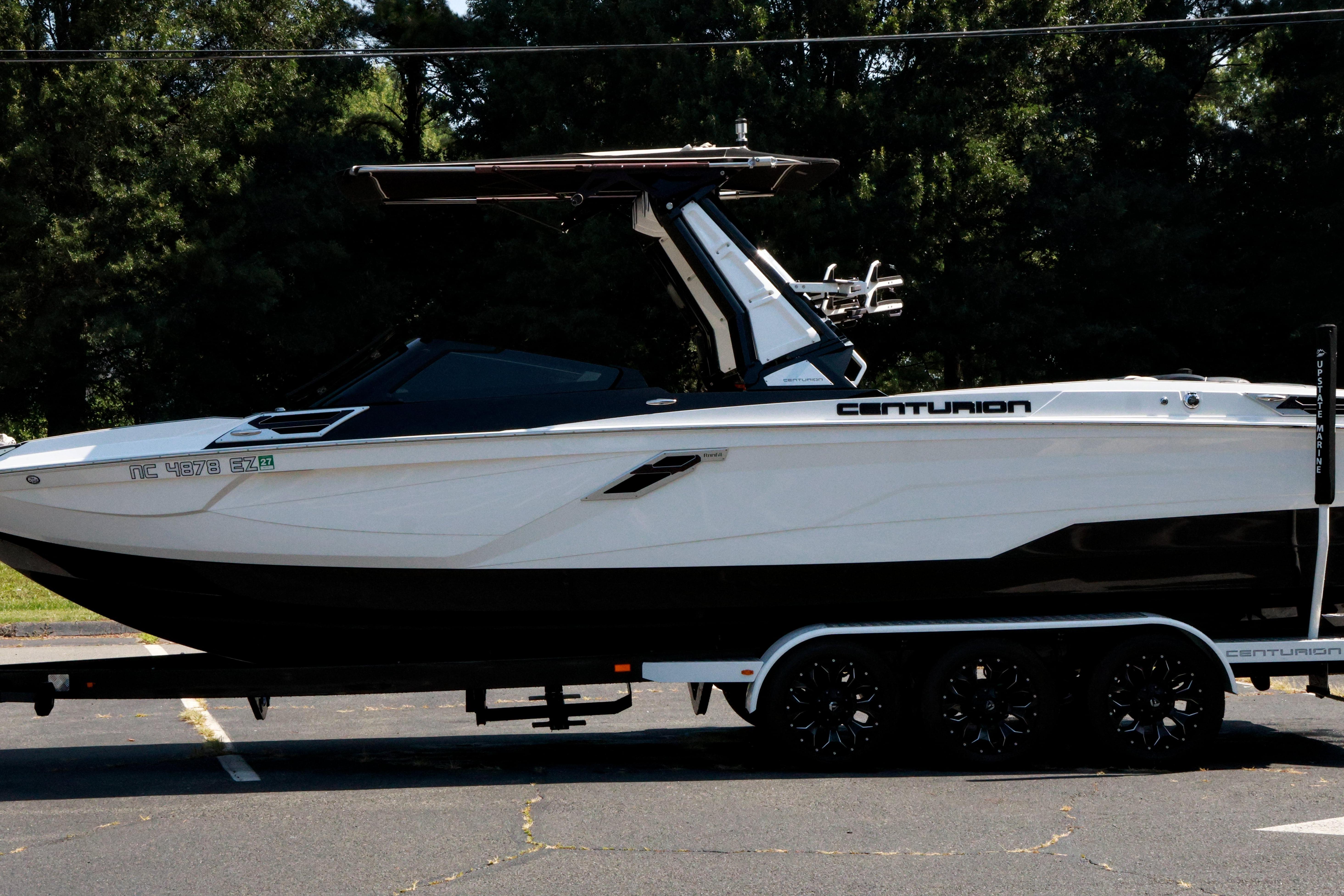 2022 Centurion Ri265 boat on trailer, parked outdoors with trees in background.
